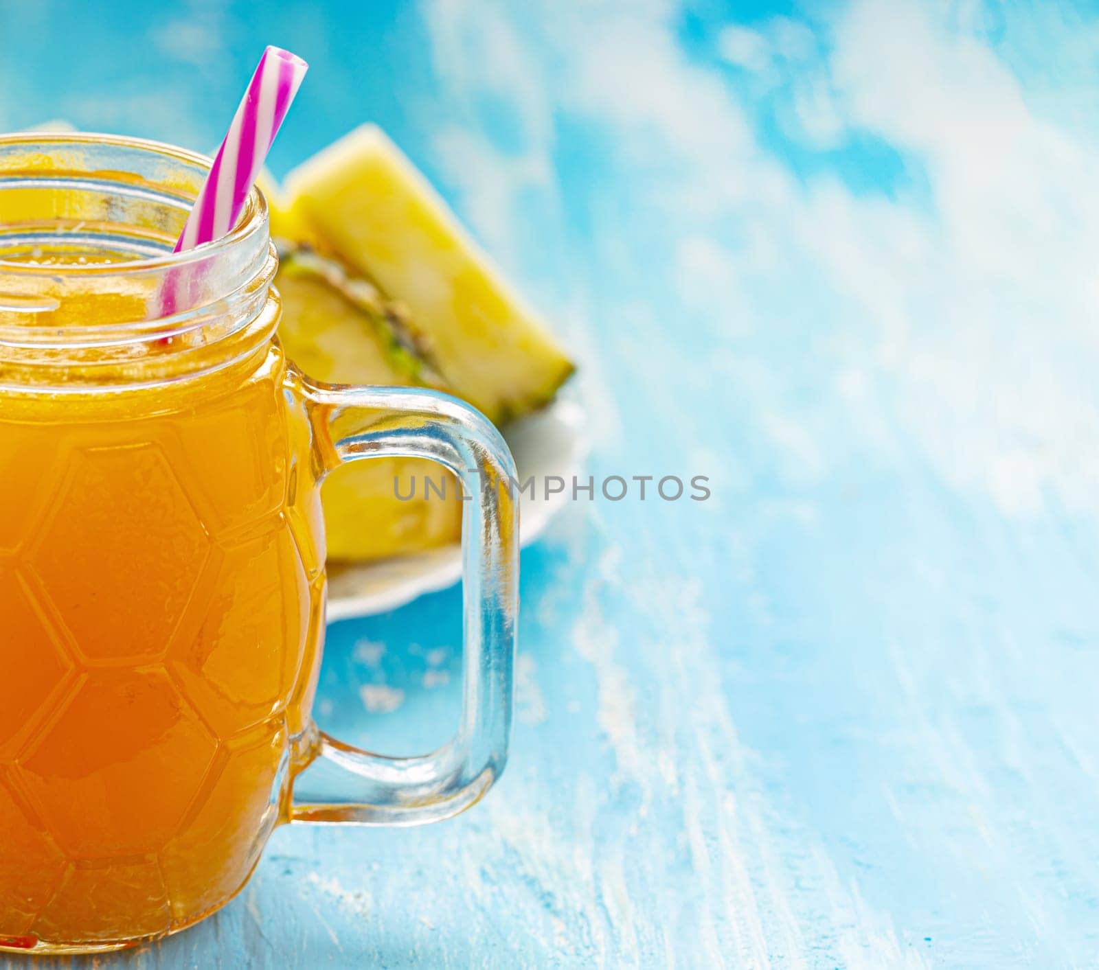 The Pineapple juice or smoothies in a mug with a pen on a blue wooden table