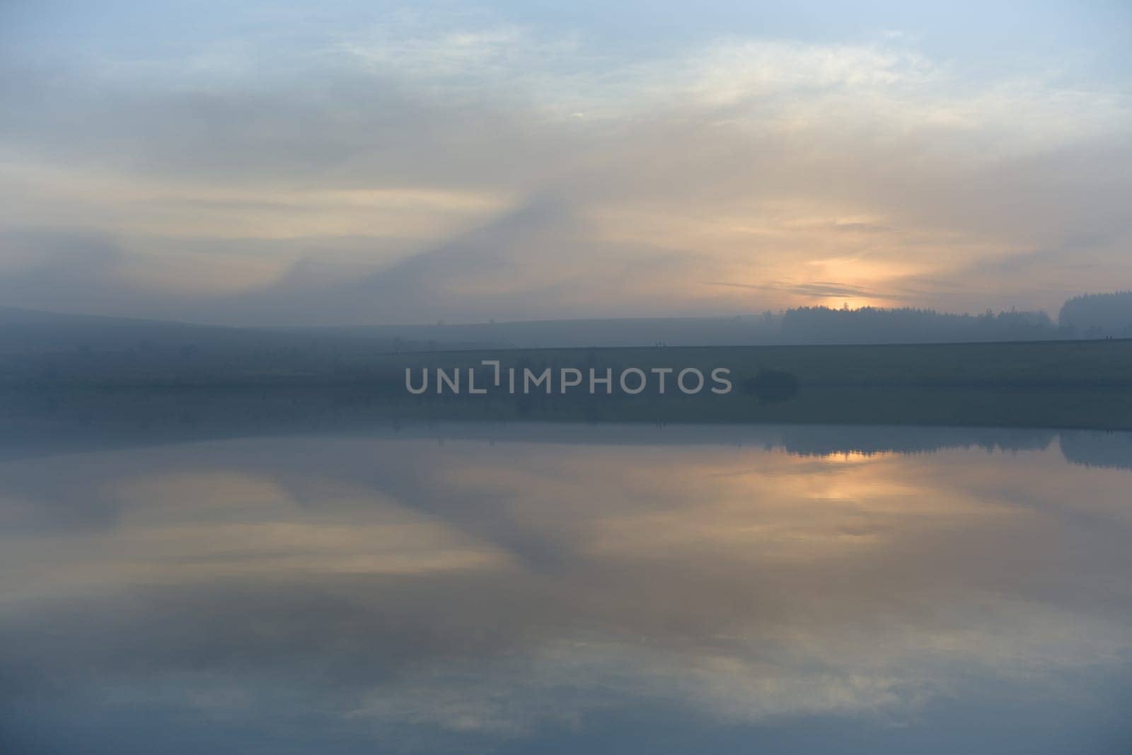 Pastel colors and wispy clouds hang in the sky just after the sun has set over redmires reservoirs. In the peak district near to sheffield.