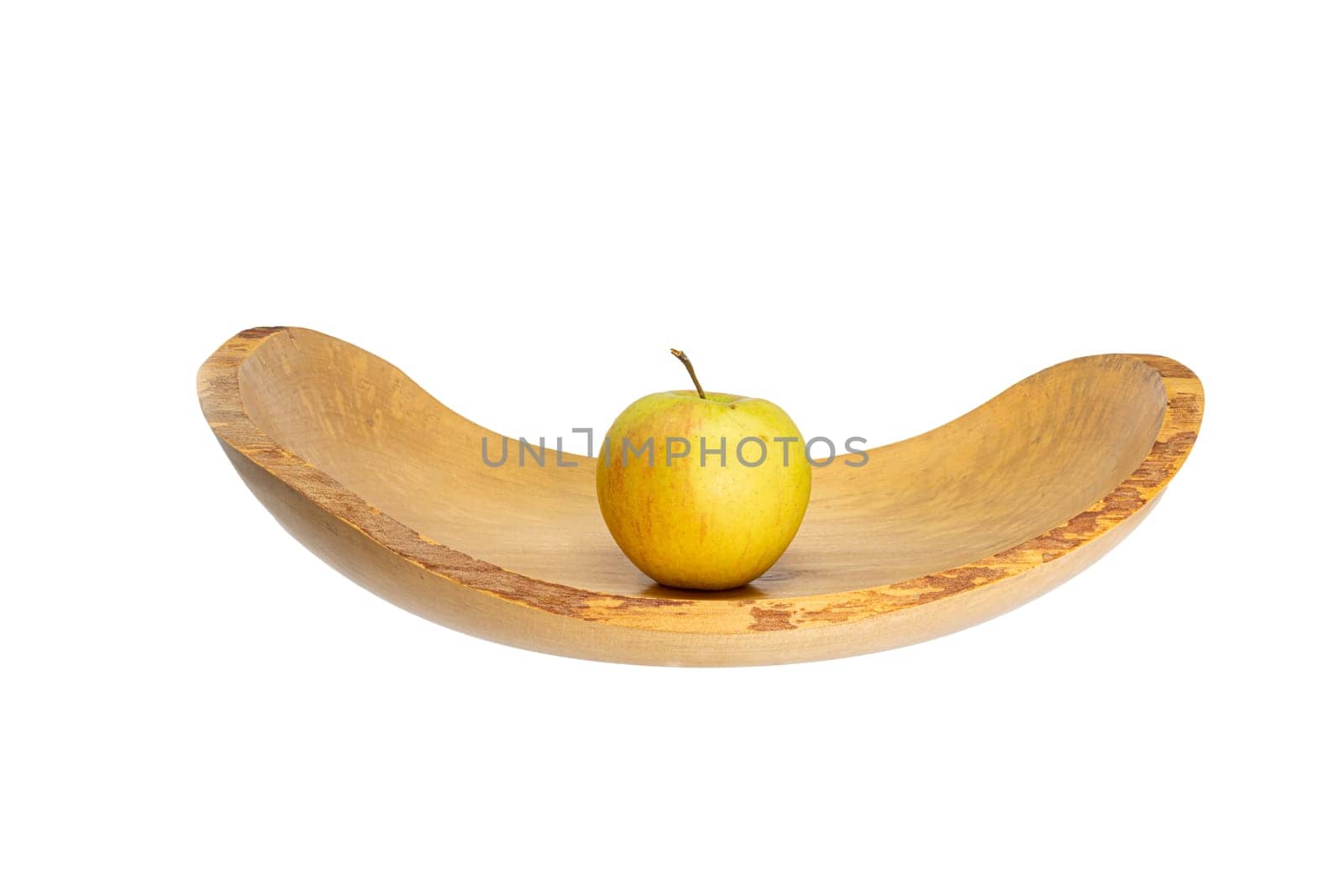 Side view of a flat wooden bowl with an apple in the middle isolated on white