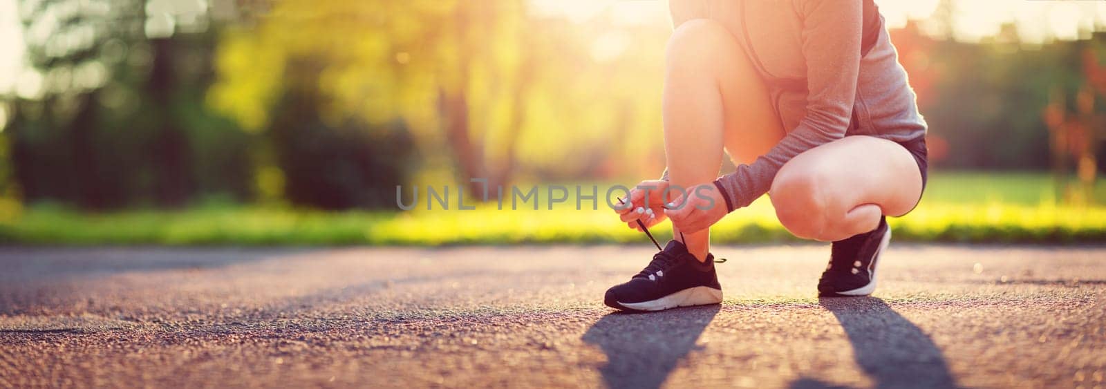 Young woman running in the park. Active person outdoors at the dusk in summer