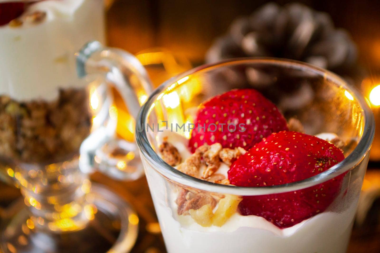 Healthy dessert with cream, muesli and fresh strawberry on holiday background