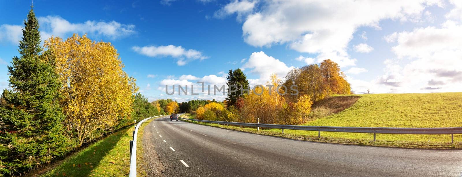 beautiful landscape on a highway in autumn. Road at falls on sunny day