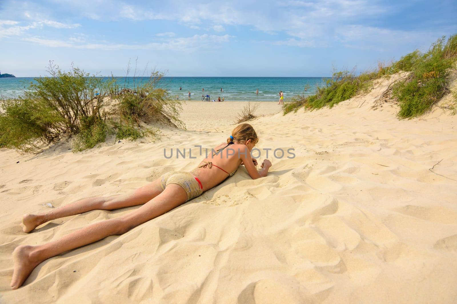 Girl sunbathes on a wild sandy sea beach