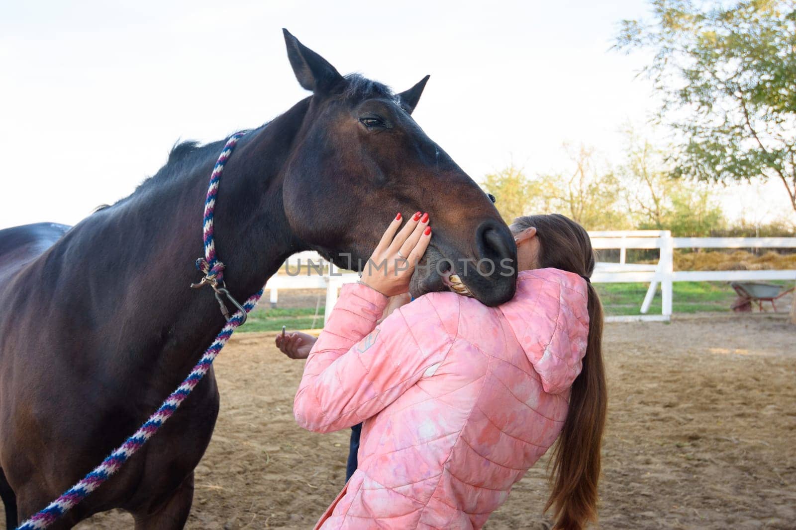 The horse tries to bite the girl on the shoulder