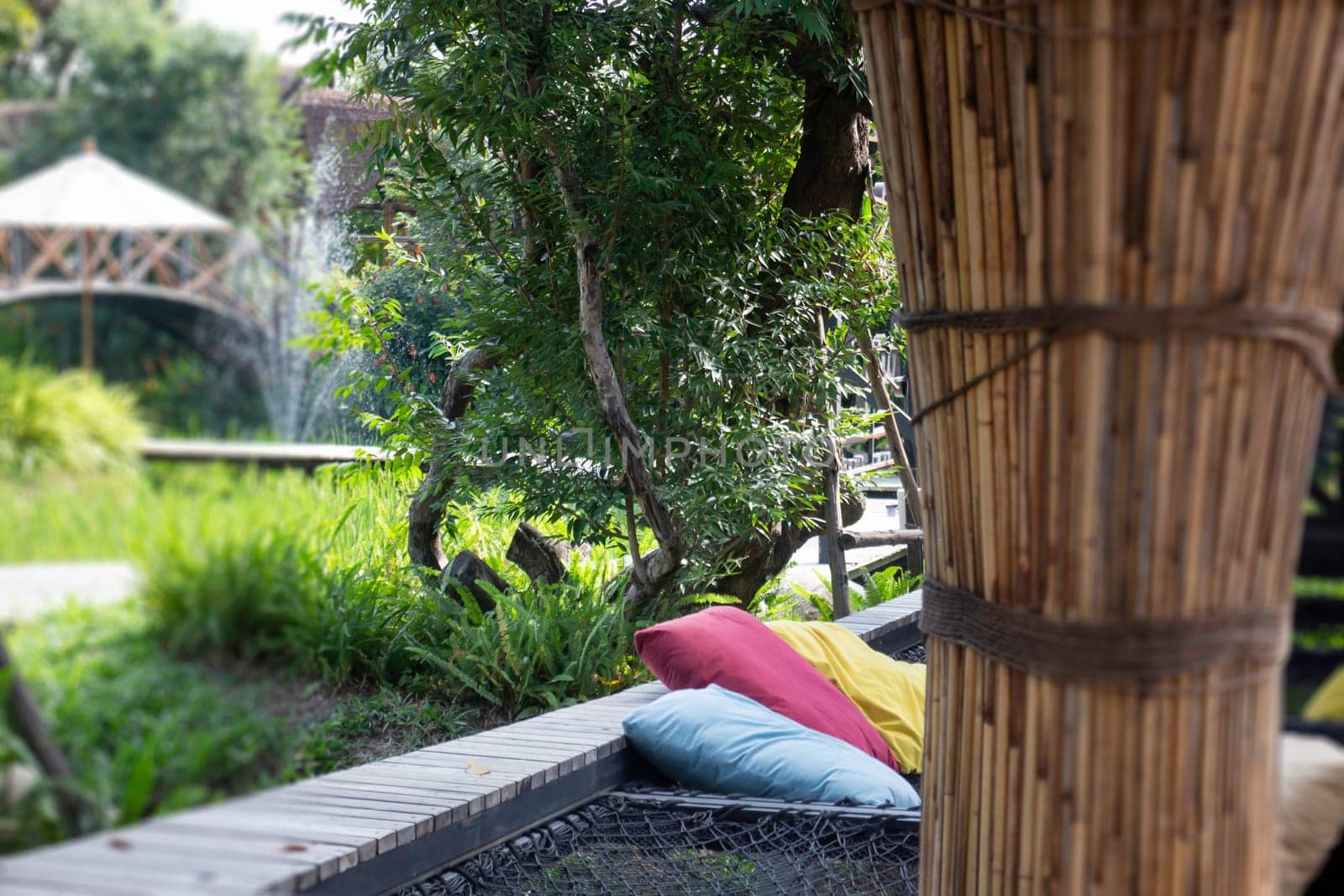Colorful pillows on net seat among nature, stock photo