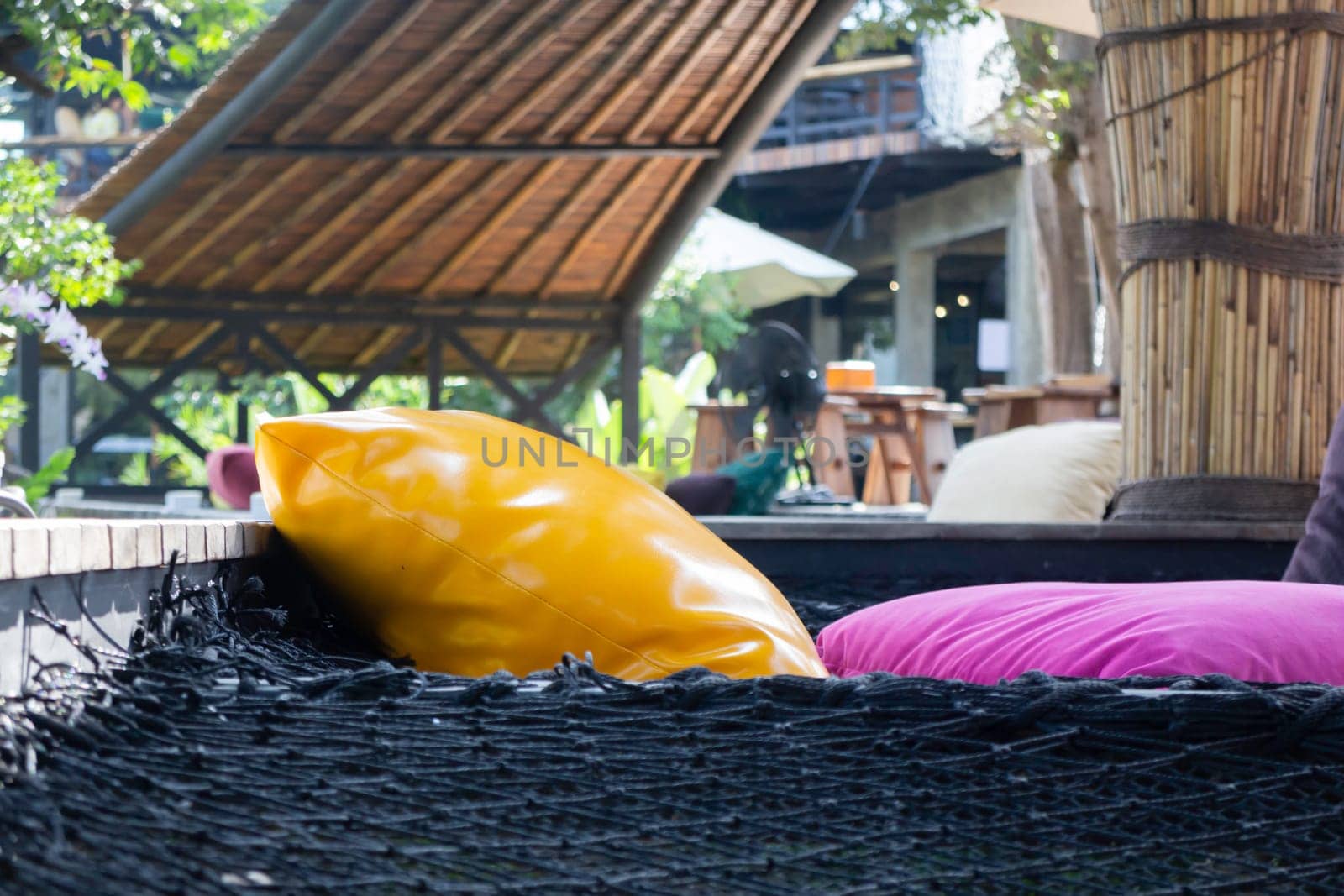 Colorful pillows on net seat among nature, stock photo