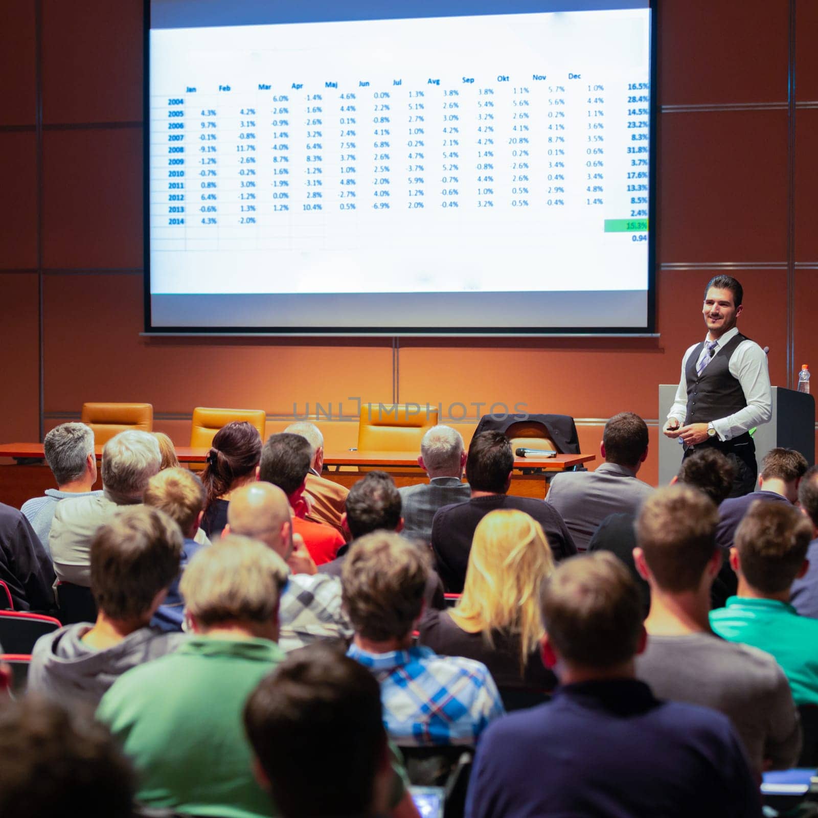 Speaker giving a talk in conference hall at business meeting event. Rear view of unrecognizable people in audience at the conference hall. Business and entrepreneurship concept.