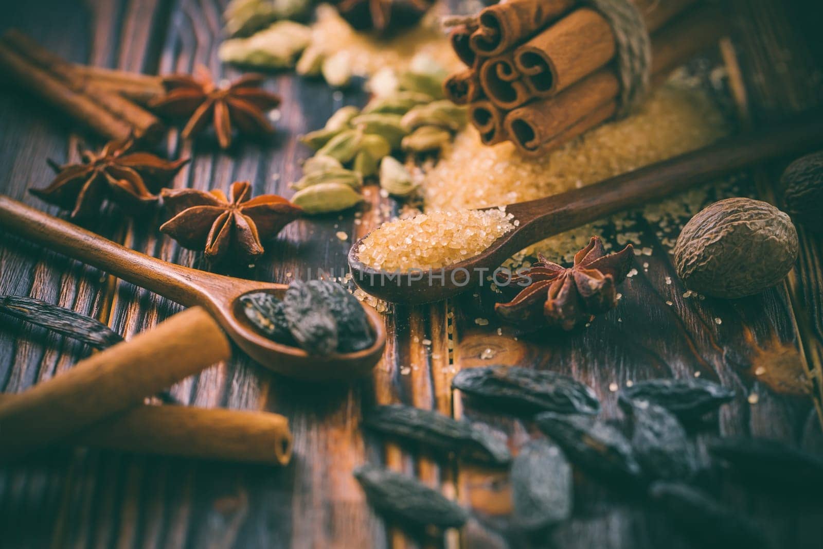 Fragrant spices for Christmas baking on wooden background.