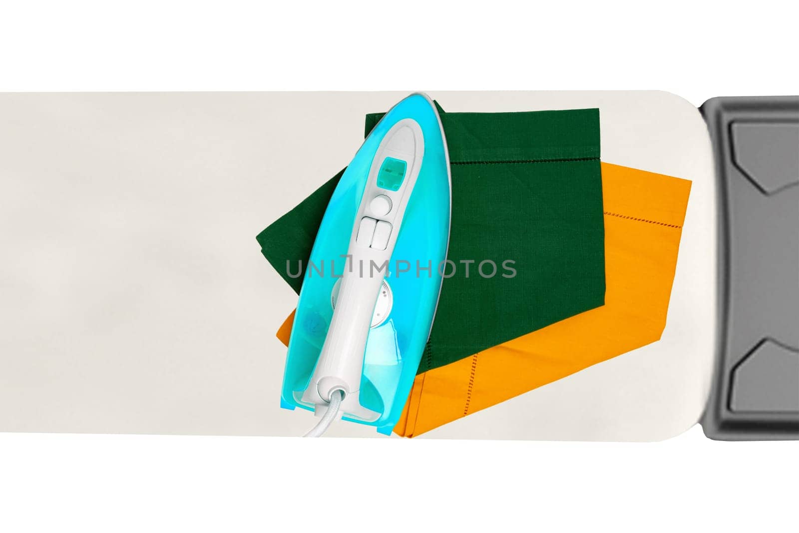 Top view of a modern electric blue iron ironing a green and a yellow cloth napkin on an ironing board indoors isolated. Advertising for the laundry service with space.