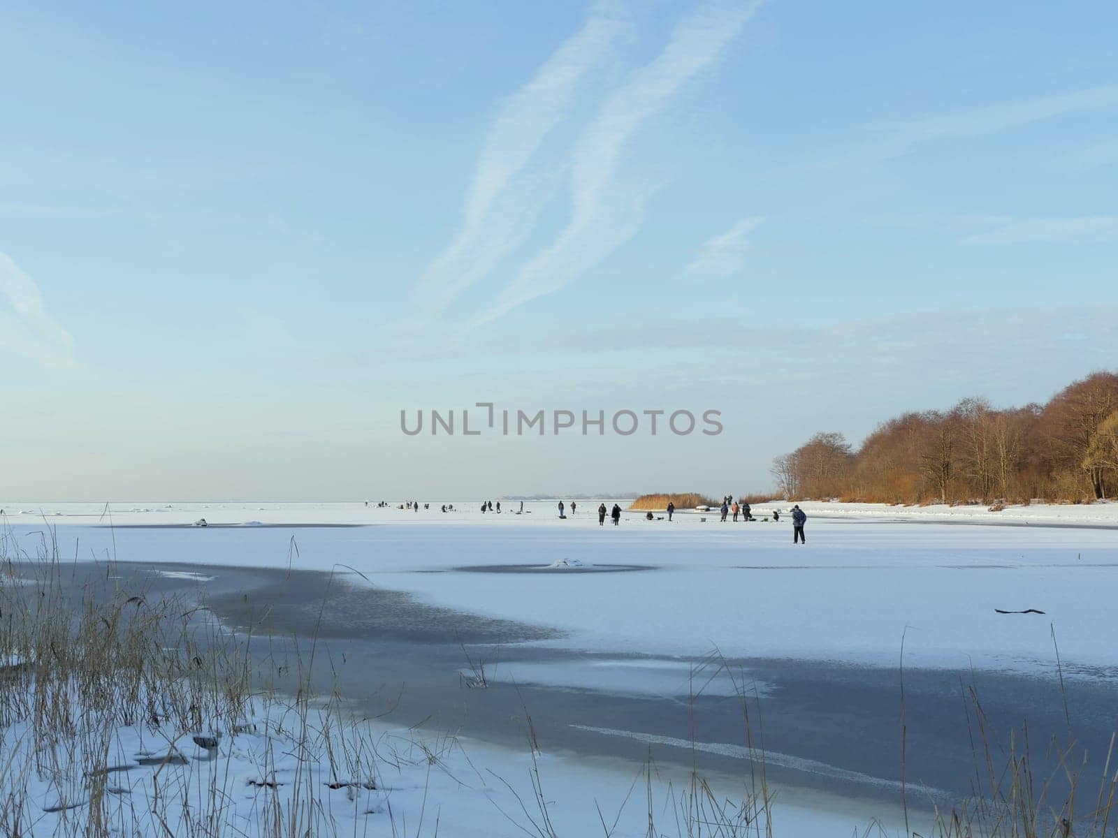 winter  ice fishing  crowd of people on the ice of a frozen and snow-covered lake catching fish