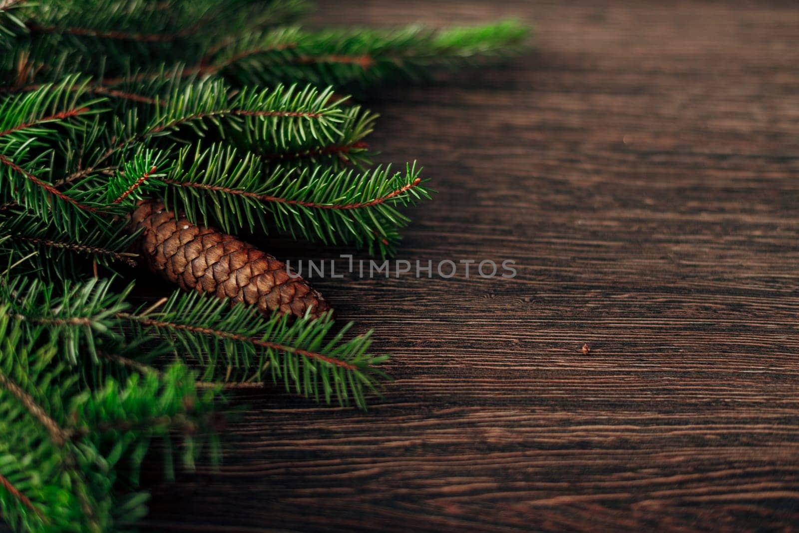 Decoration of Christmas Tree Green Branches on a Brown Background with CopySpace