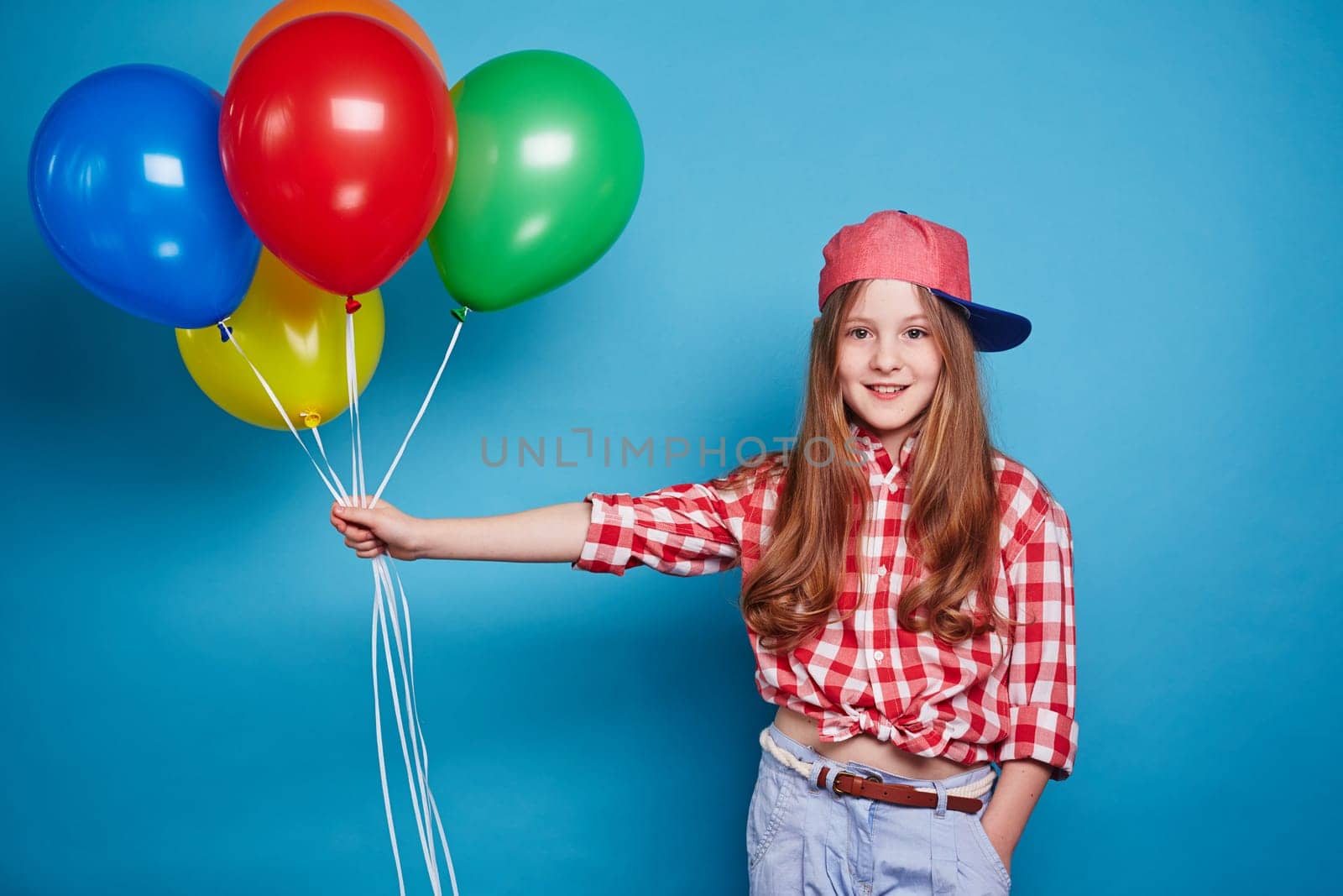 Cute girl keeping balloons on her outstretched hand