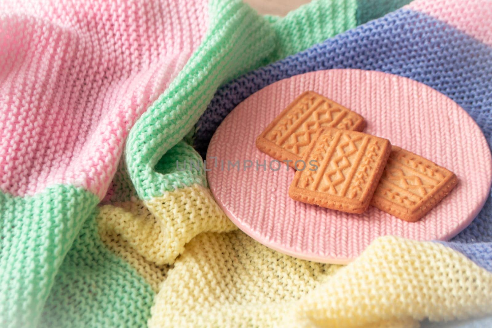 Golden cookies with knitted effect scattered on a knitted blanket. romantic mood concept. Christmas life style