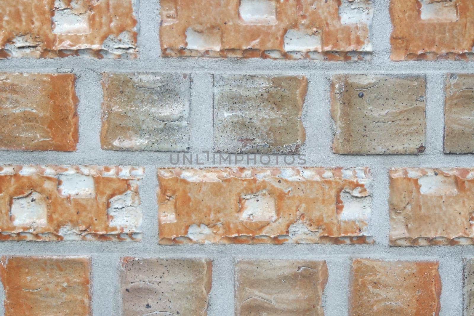 Closeup texture of black brick wall. A background of a weathered old exterior brick wall in the sunshine.