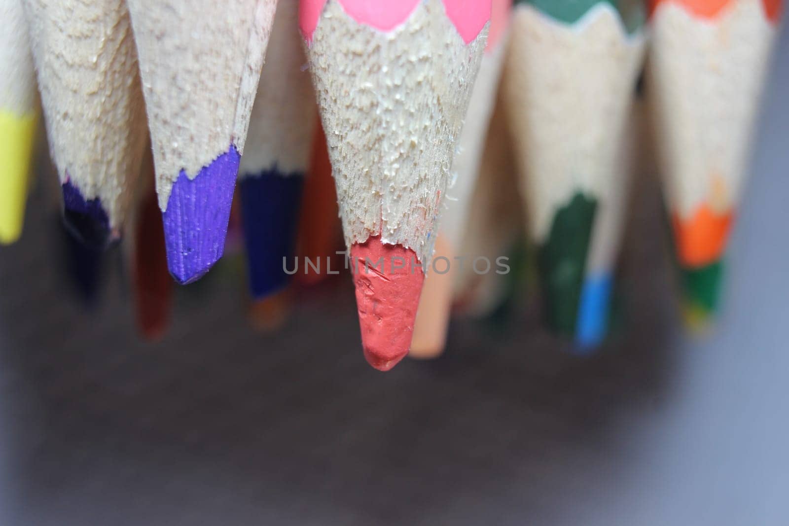 Close-up view of bright colored multicolor pencils on black background