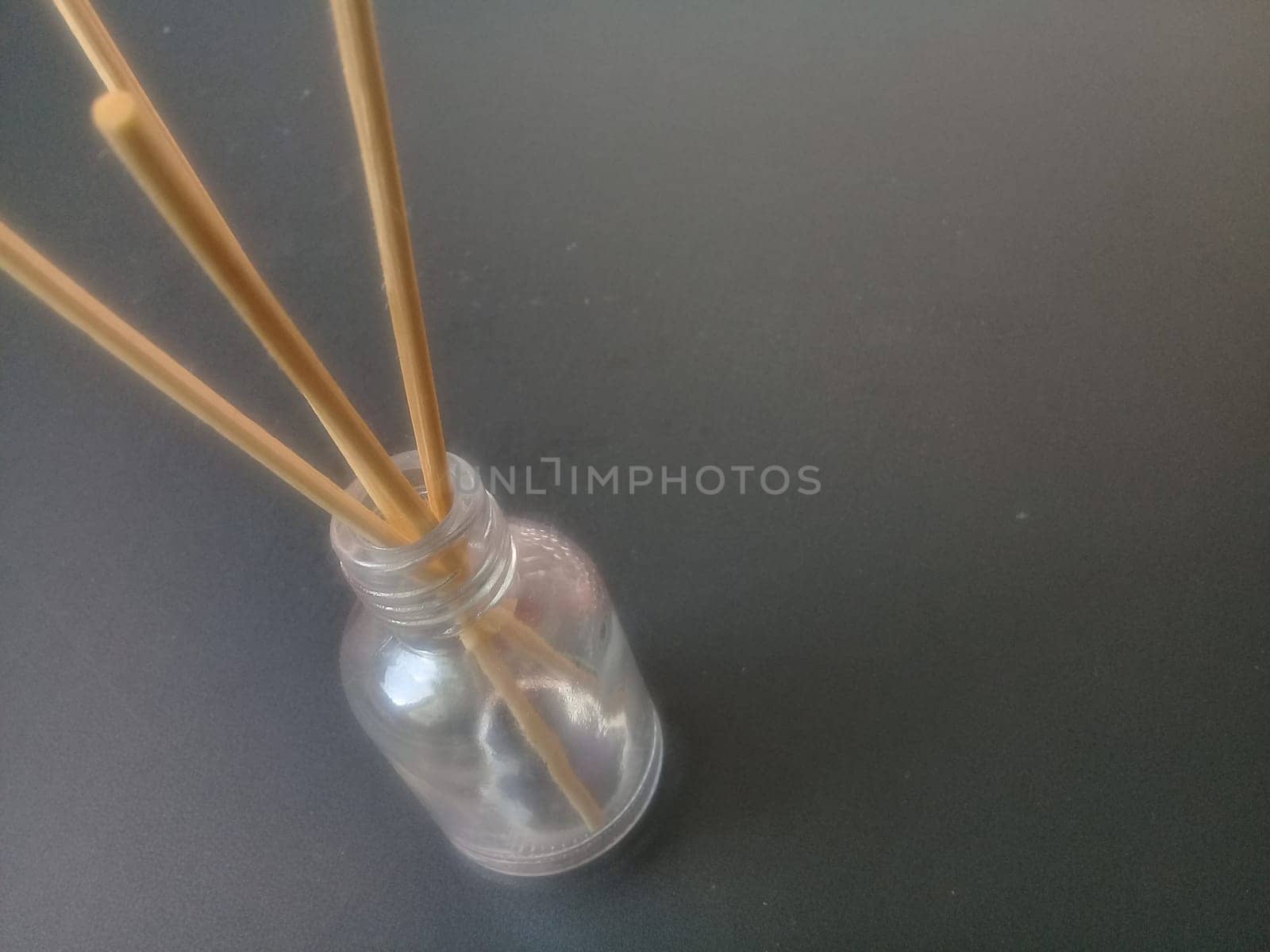 Close-Up Of Incense Sticks In glass Container Against Gray Background. Traditional aroma sticks for fragrance refreshing air