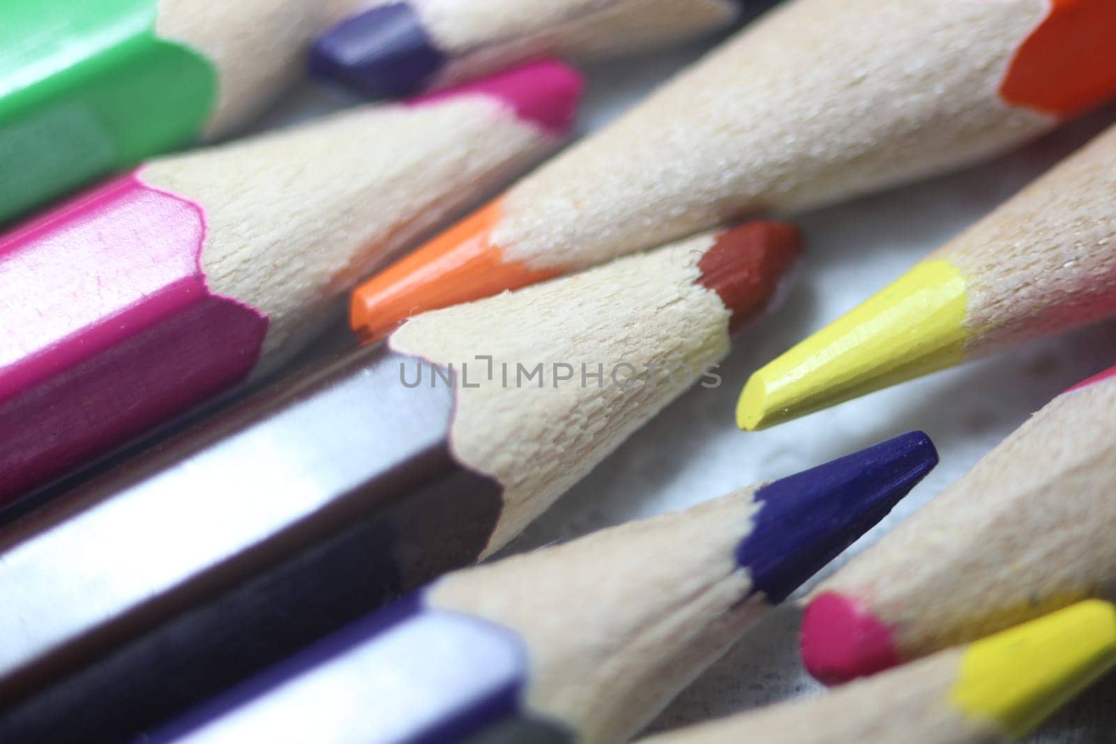 Close-up view of bright colored multicolor pencils on black background
