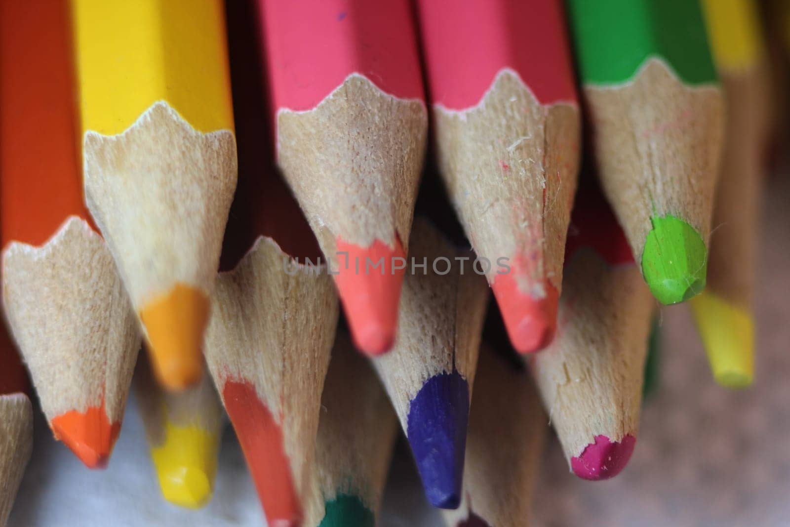 Close-up view of bright colored multicolor pencils on black background