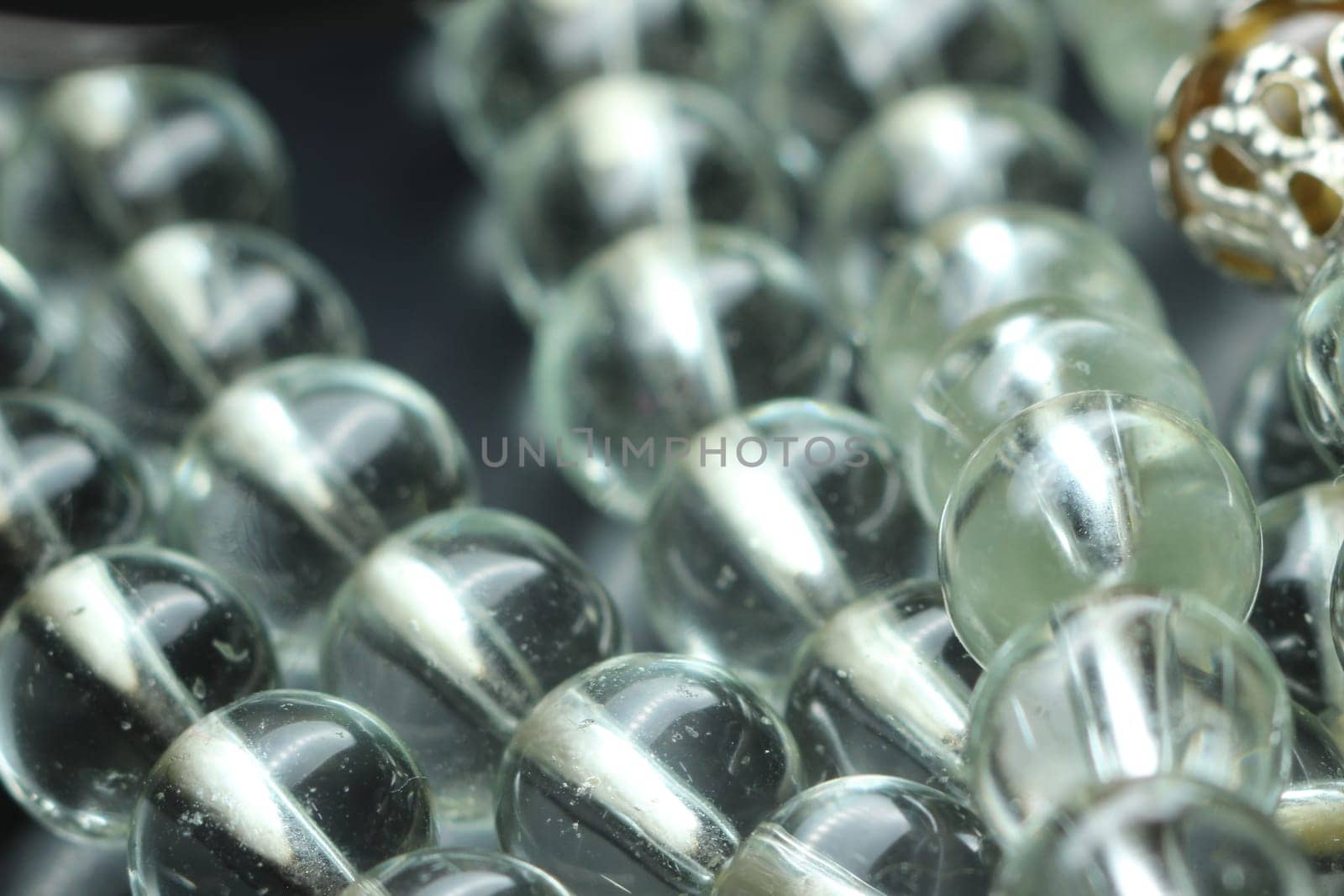 Macro photograph with selective focus of glass shiny prayer beads or rosary with copy space for text. Religion concept of ramadan or Eid for muslims.