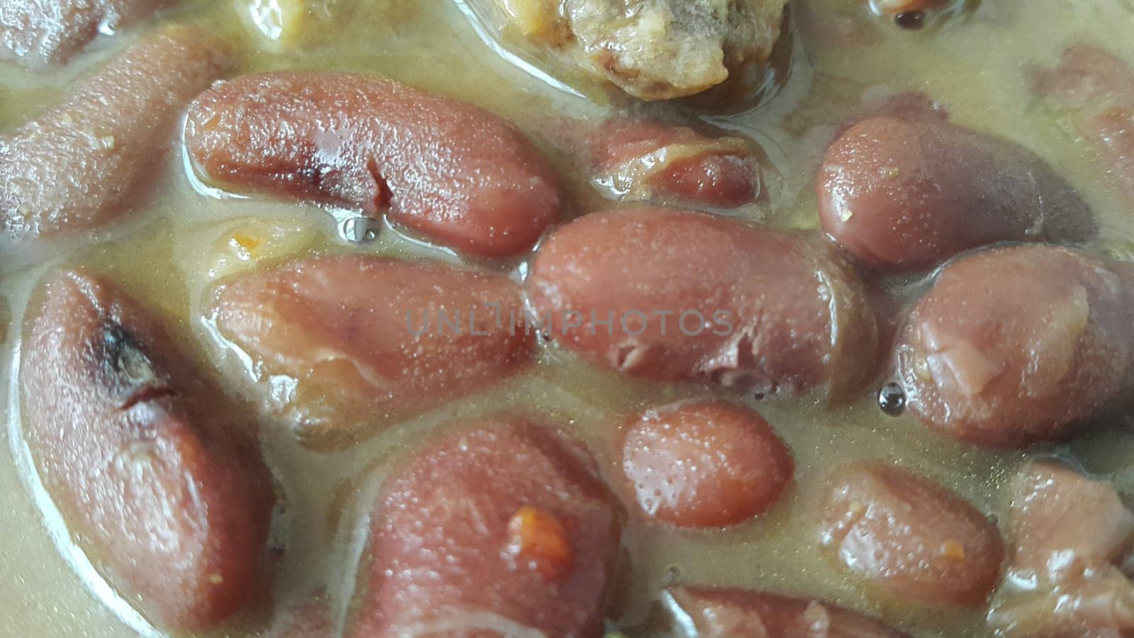 Kidney beans dish:  Closeup view of cooked red kidney beans dish. Dark red useful beans dish background.