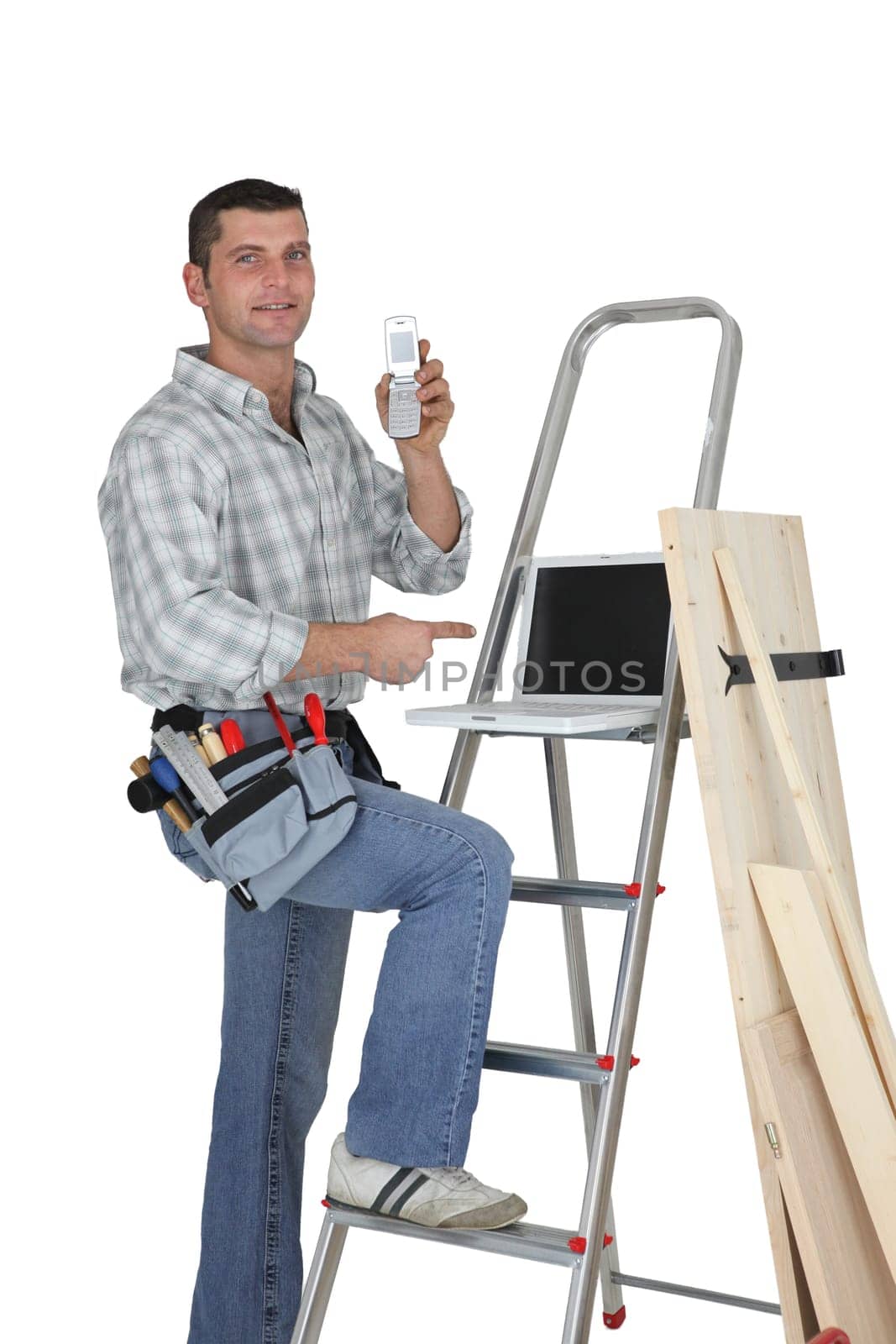 Carpenter standing by a ladder with  a mobile telephone