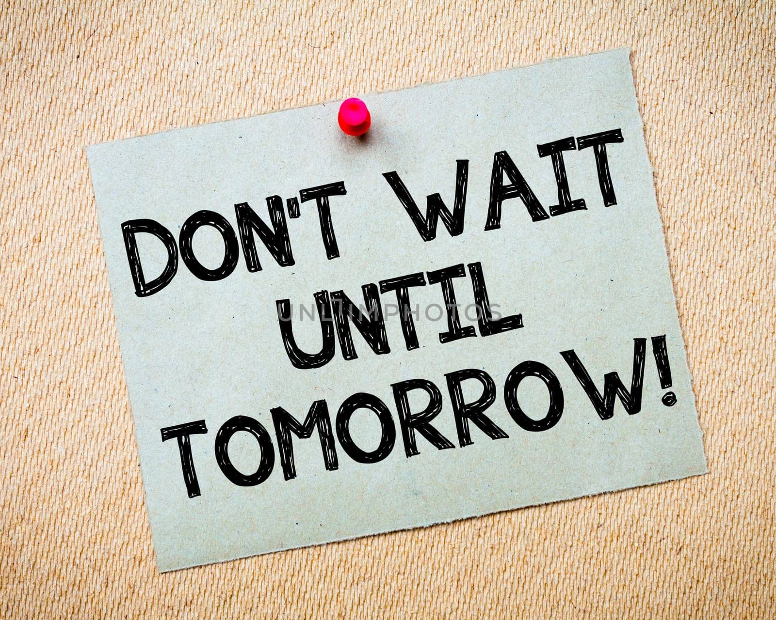 Recycled paper note pinned on cork board.Don' t Postpone Message. Motivational Concept Image