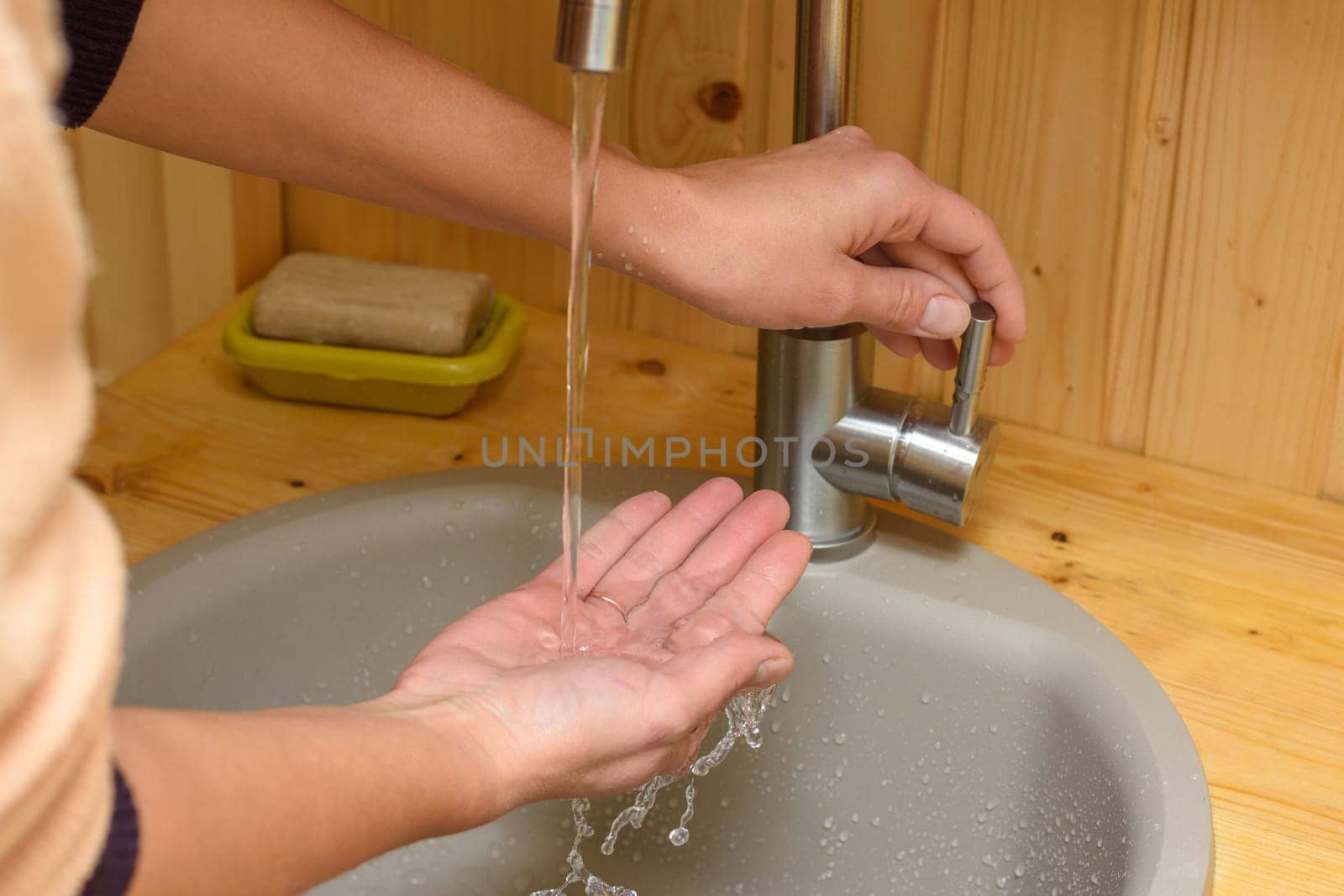 Tap water pours into the girl's hand
