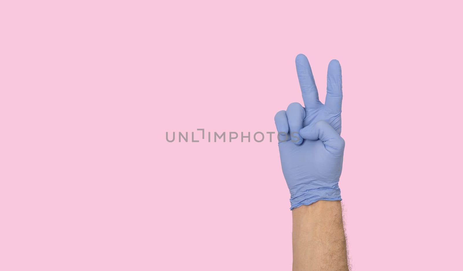 Hands gestures. human hand in latex glove showing fingers in the air symbol isolated on pastel pink background with copy space. irony, sarcasm concept
