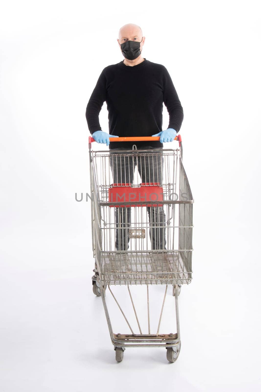 Man with mouth protection and hand gloves pushing a shopping cart, isolated on white background