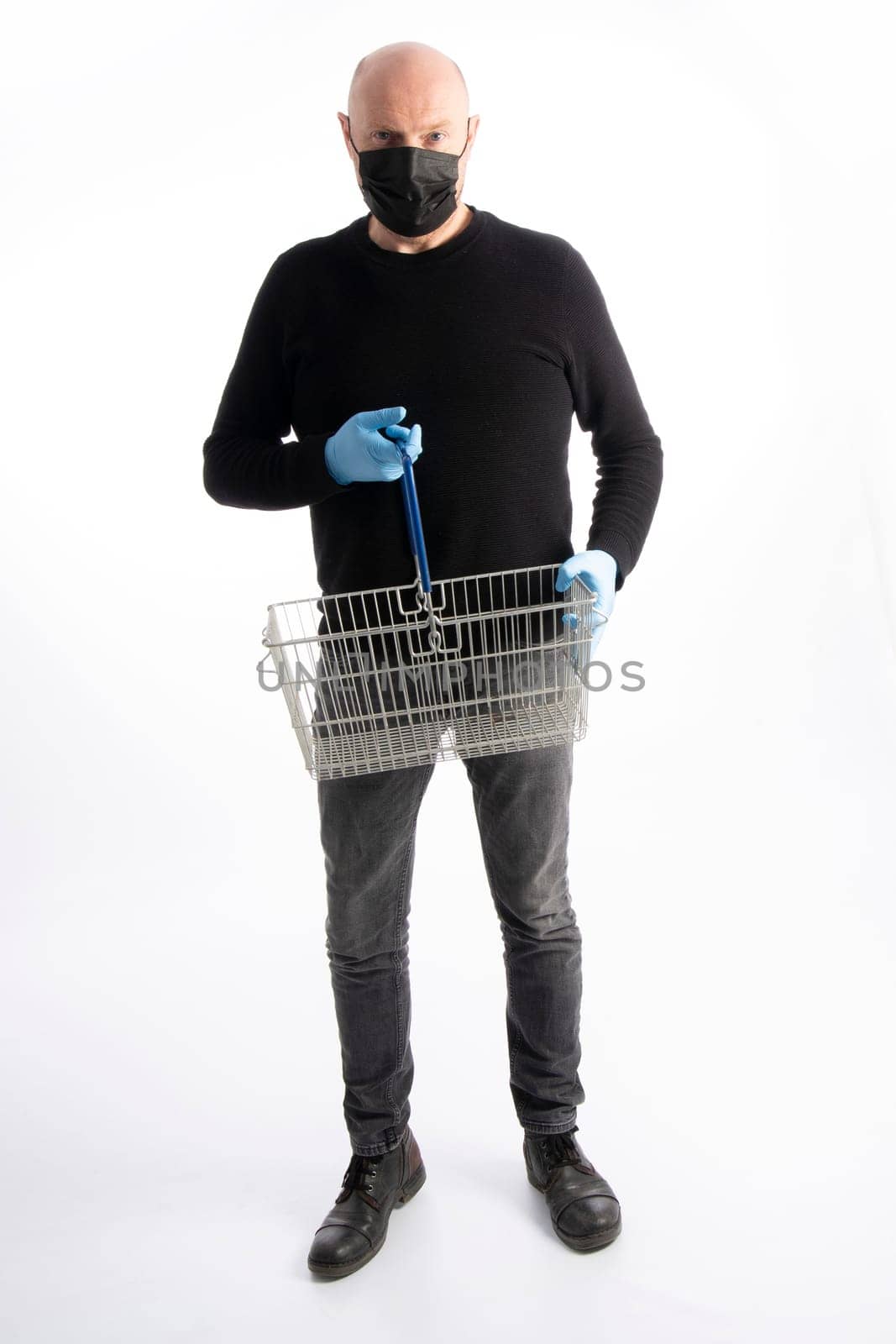 Man with mouth protection and hand gloves holding a  shopping basket, isolated on white background