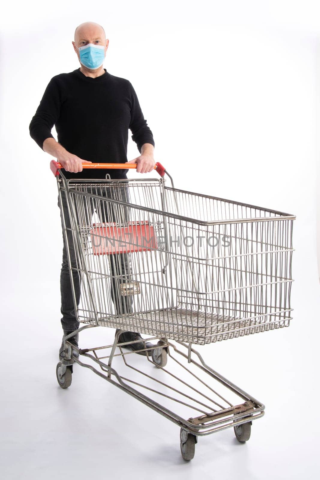 Man with mouth protection pushing a shopping cart, isolated on white background