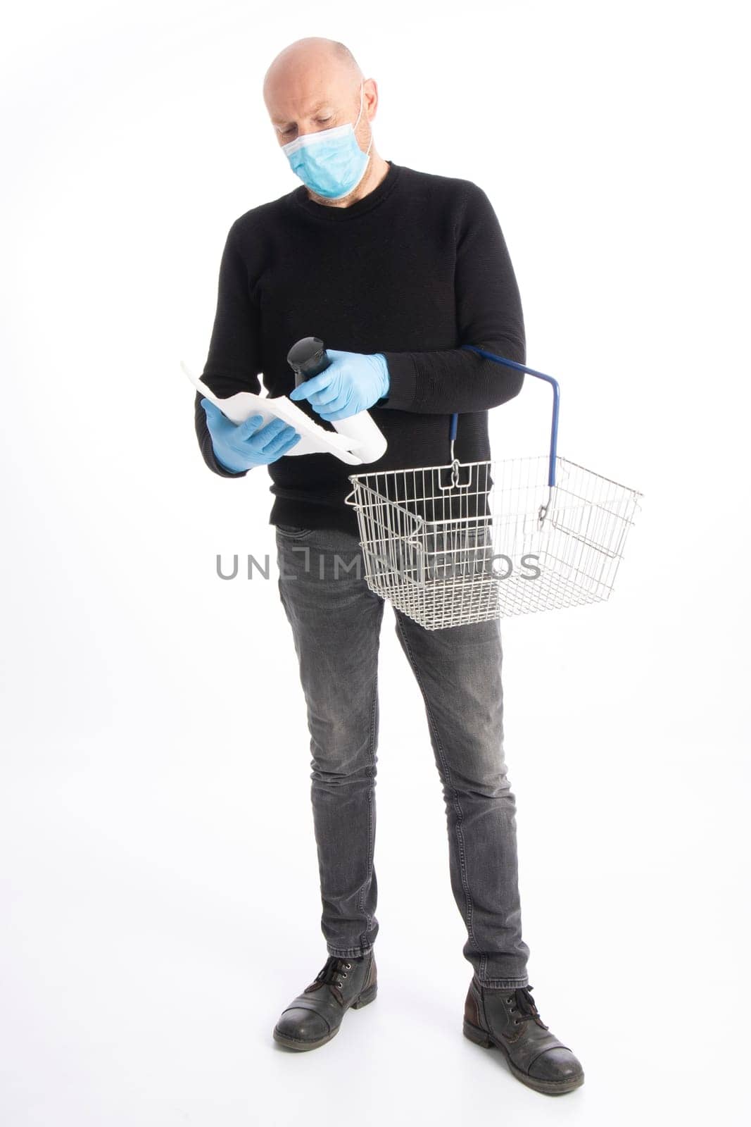 Man with mouth protection and hand gloves starting to clean a shopping cart, isolated on white background