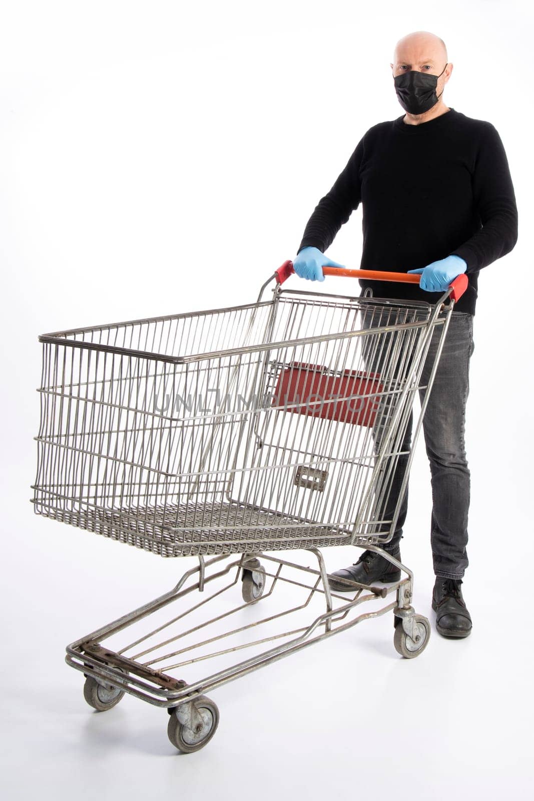 Man with mouth protection and hand gloves pushing a shopping cart, isolated on white background