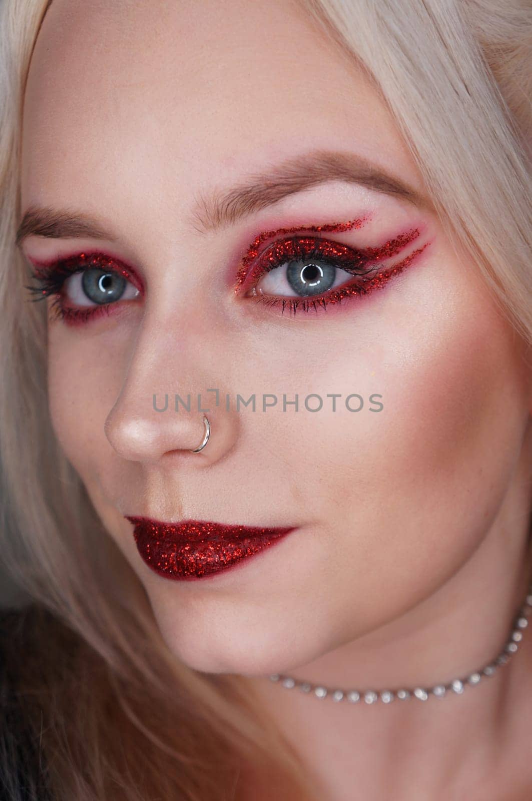 young blond woman with red glitter makeup