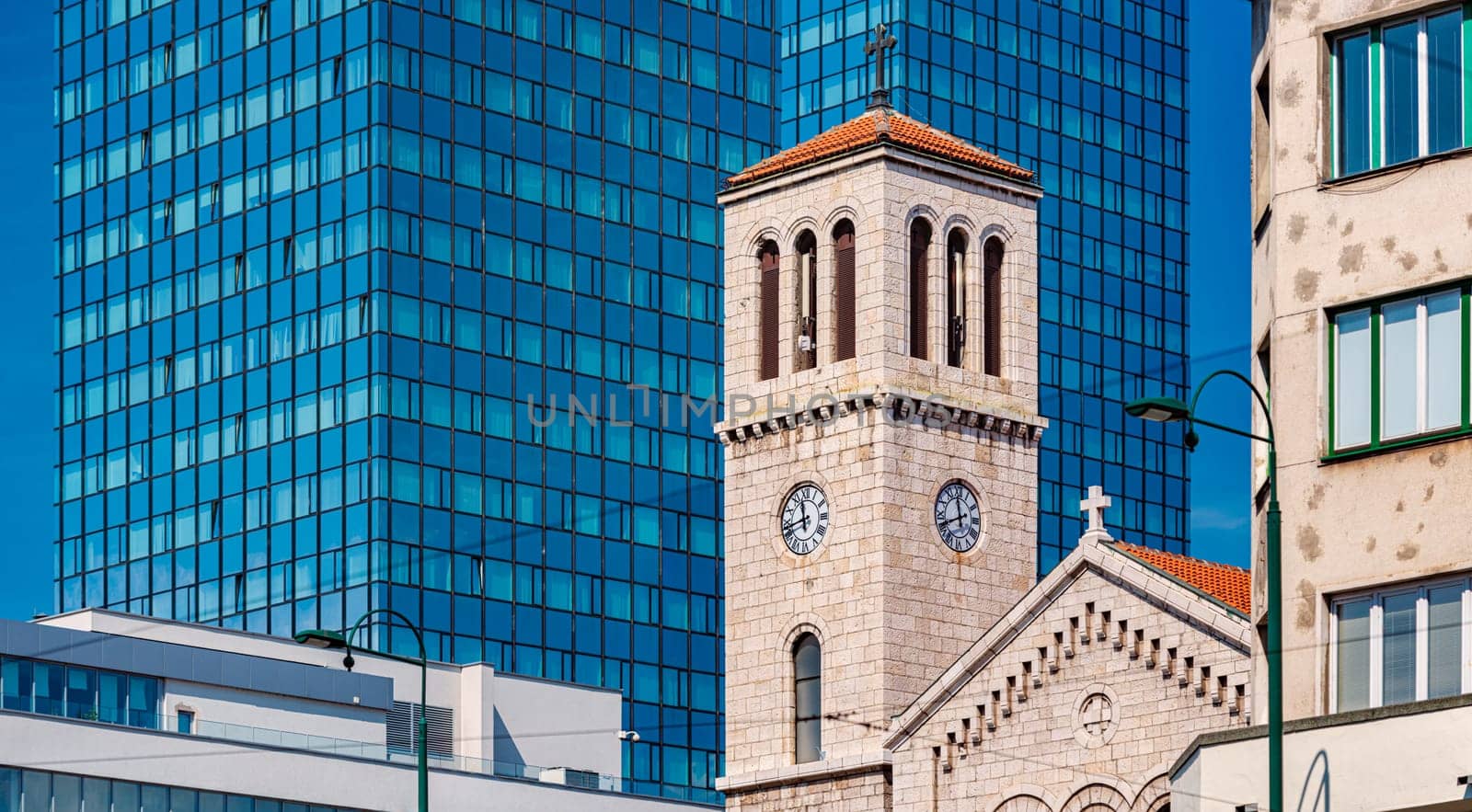 Old and new architecture in Bosnia and Herzegovina, Europe. Old and classical church building against new office building.