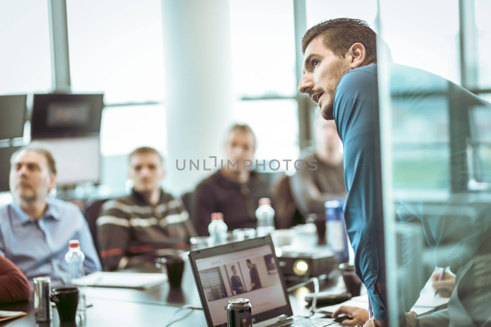 Business man making a presentation at office. Business executive delivering a presentation to his colleagues during meeting or in-house business training, explaining business plans to his employees.