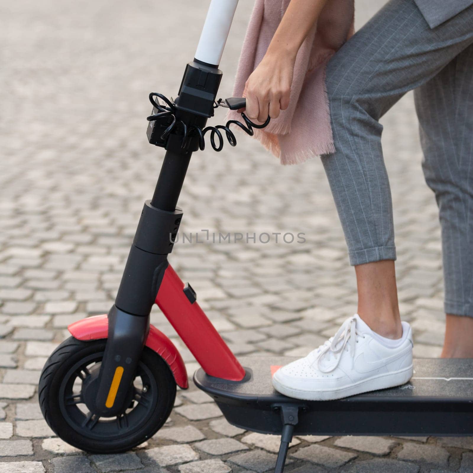 User unlocking rental electric scooter. Eco friendly green modern urban mobility concept of sharing transportation with electric scooters for rent in Ljubljana, Slovenia.