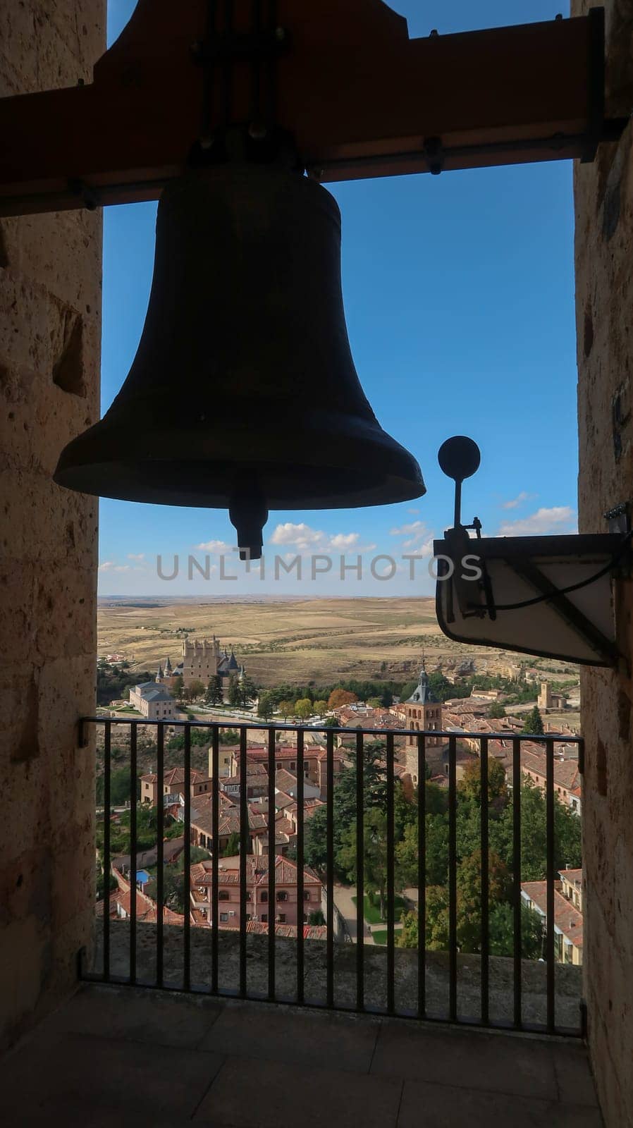 Bell tower of Cathedral of Segovia in Spain with Segovia Castle in the distance