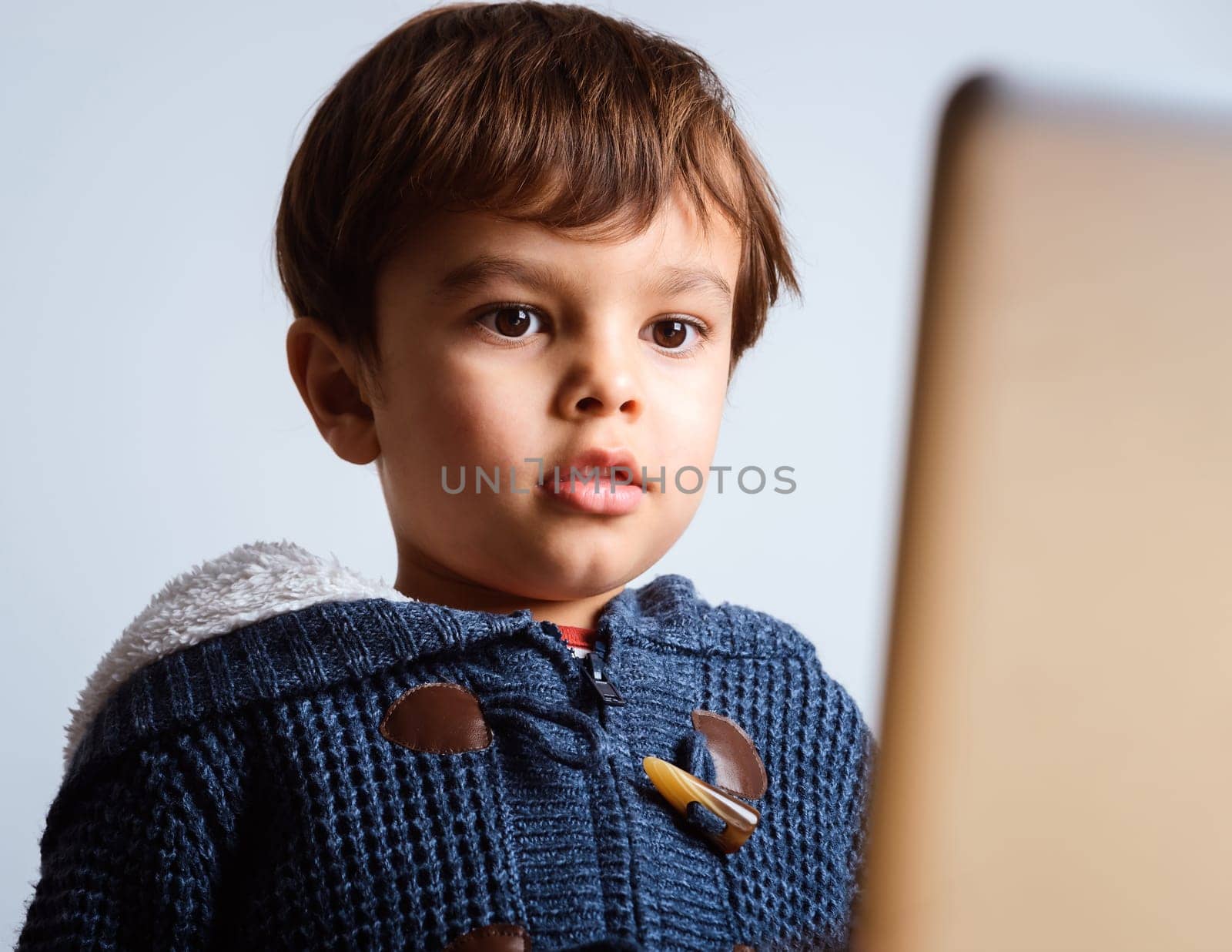 Cute little boy watching cartoon on laptop screen