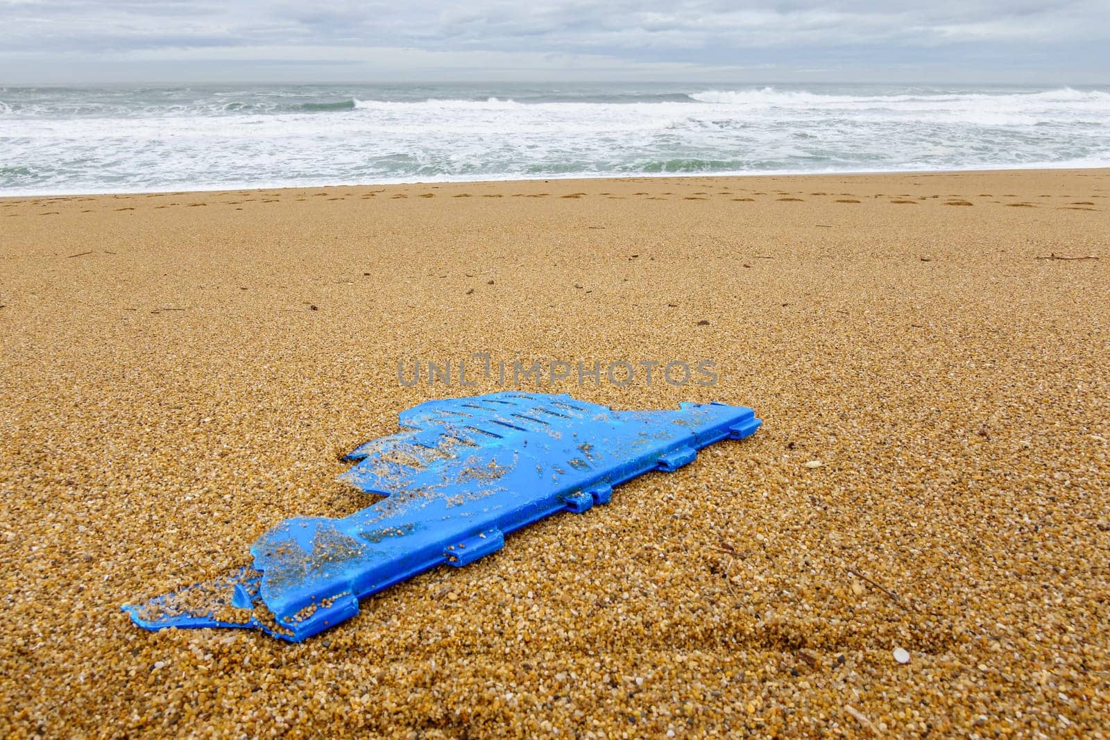Big piece of blue plastic on beach, pollution concept, Atlantic Ocean in France