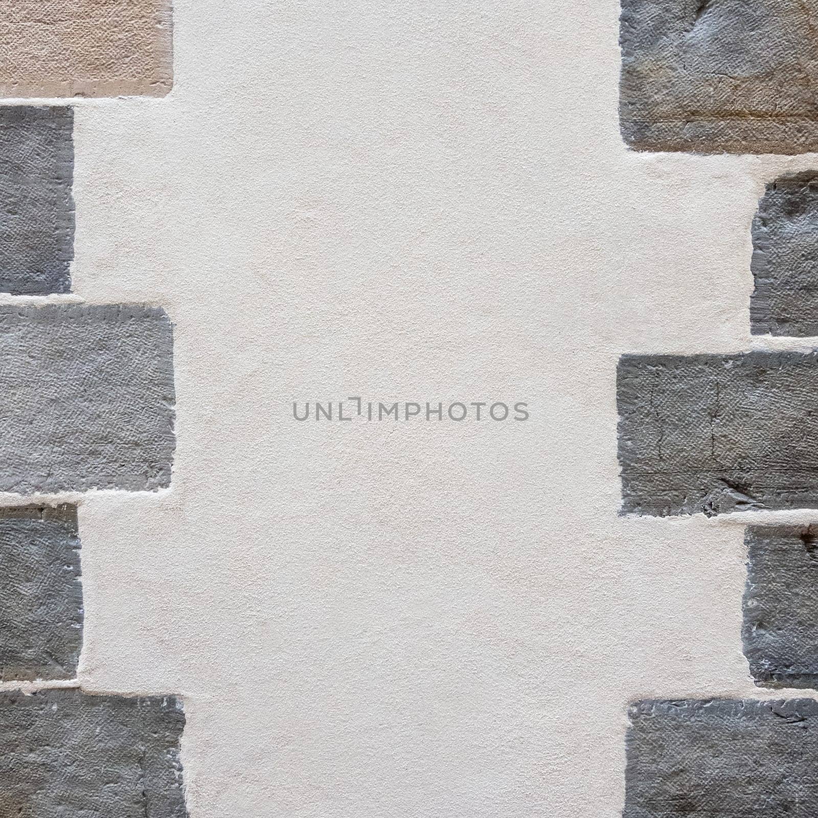 Plastered wall texture with stones on the sides, old renovated building detail shot