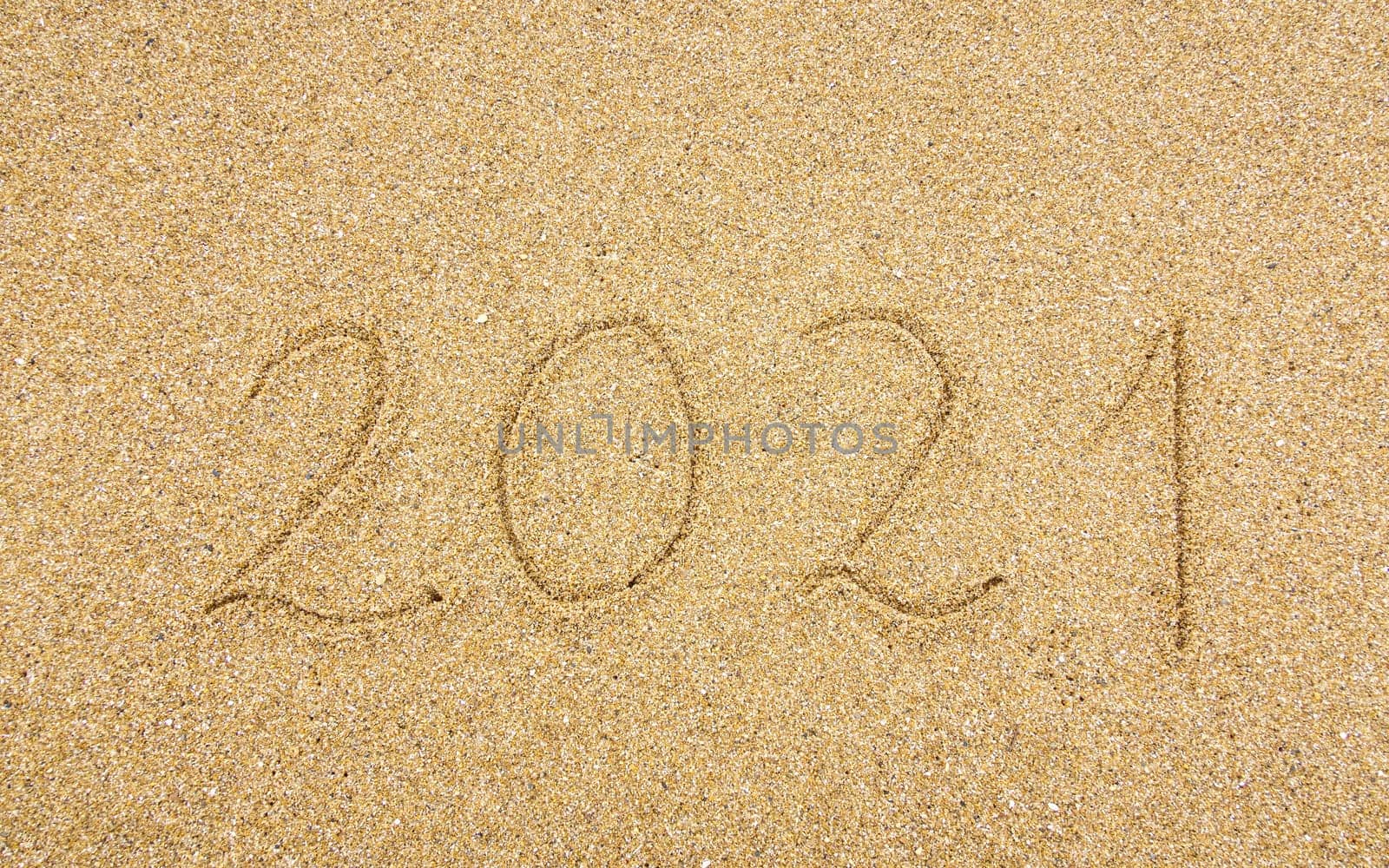 2021 handwritten on beach sand, new year and holiday concept