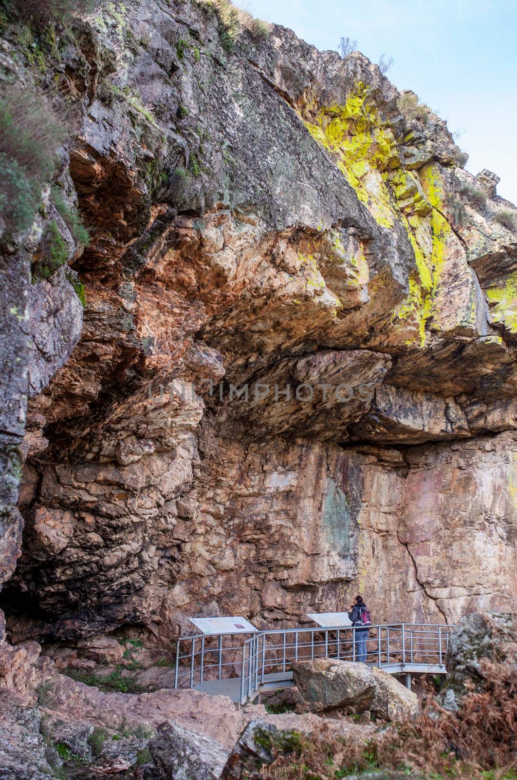 Visitor at Chiquita Cave, rock shelter with prehistorical paintings at Villuercas geopark. Canamero, Caceres, Extremadura, Spain