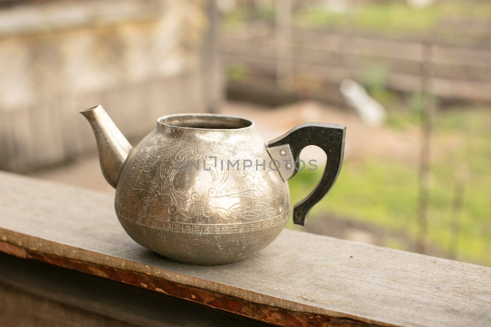 an old metal teapot without a lid.