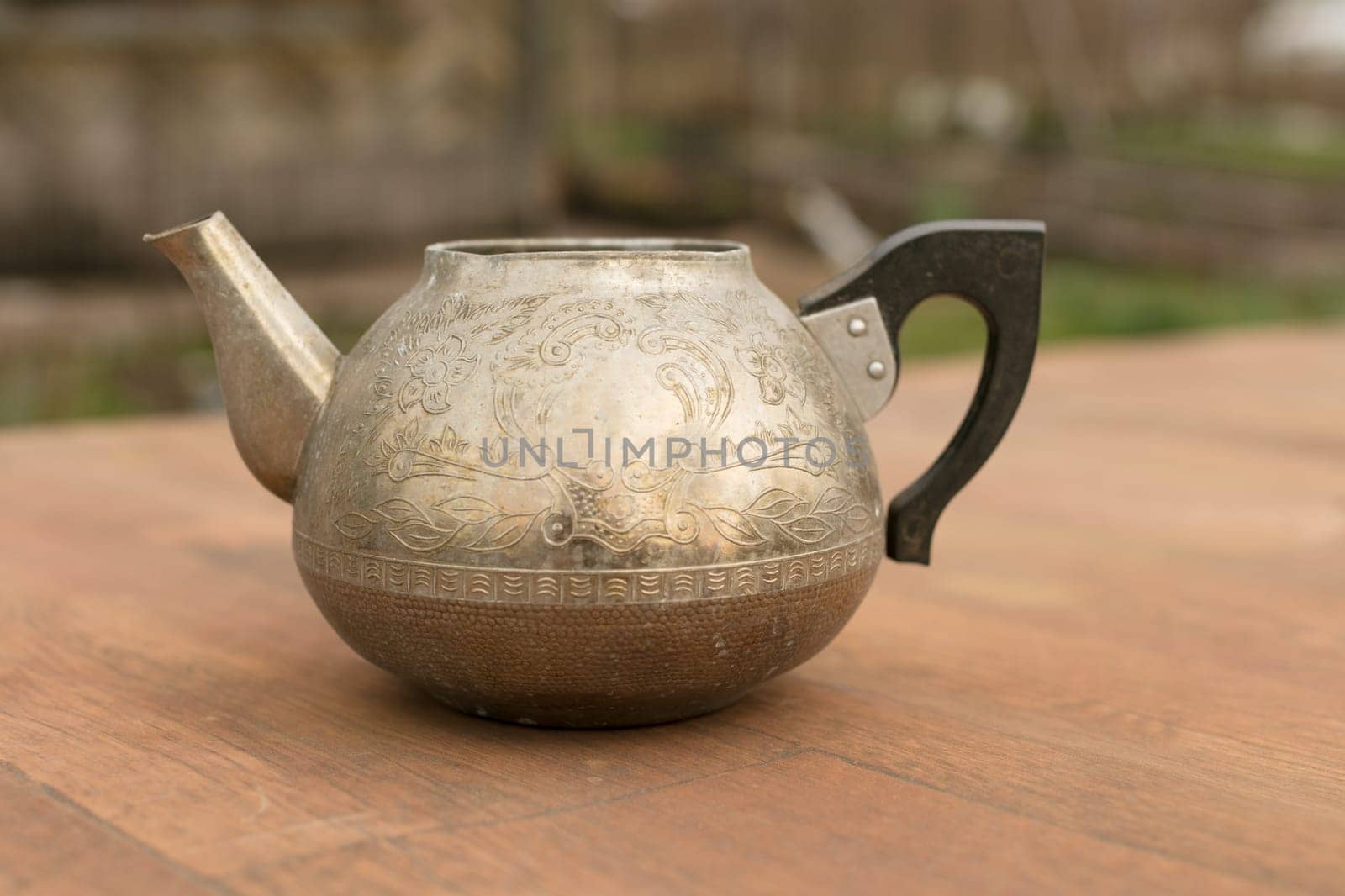 an old metal teapot without a lid.