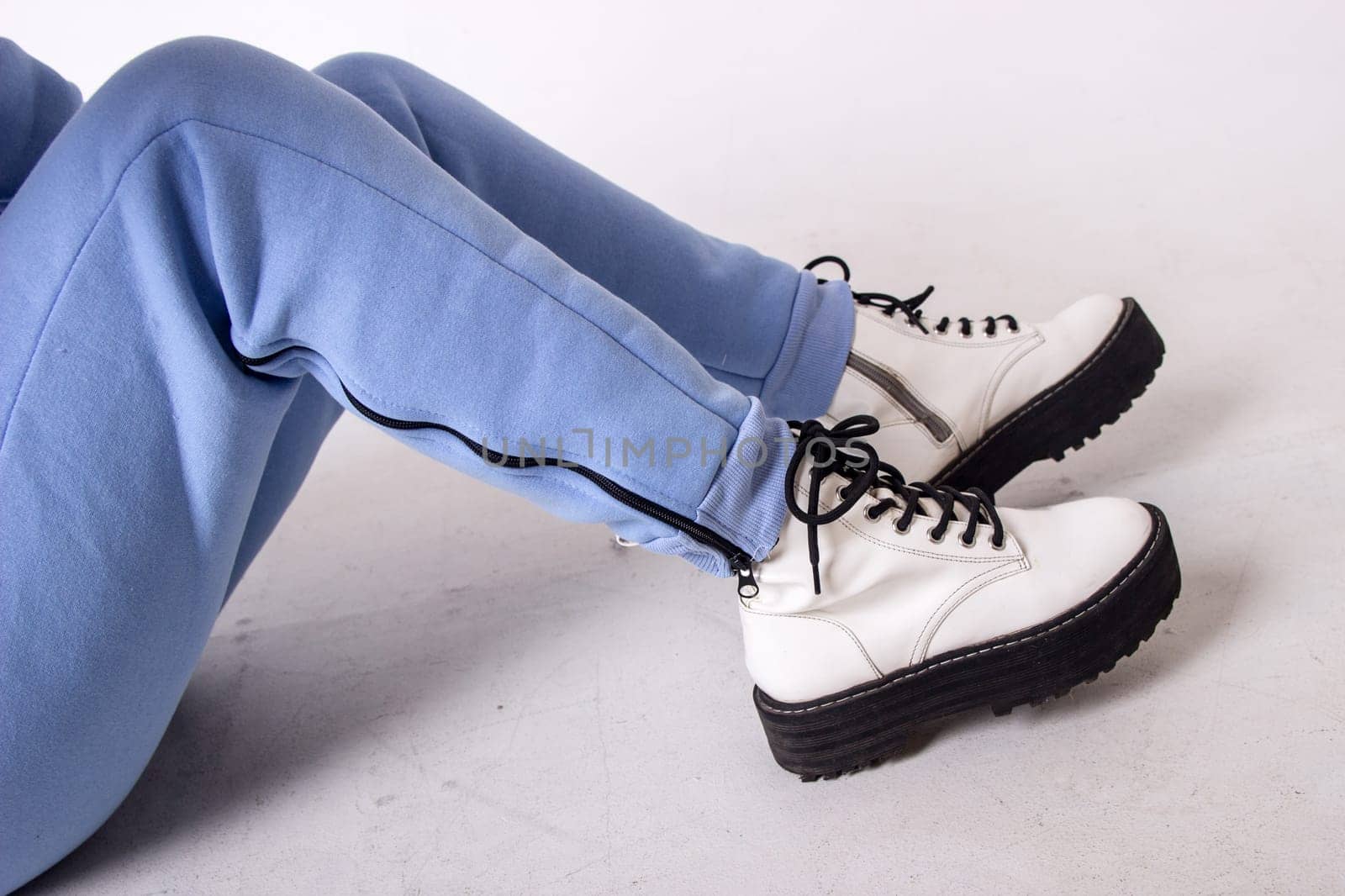 Female sneakers. White female shoes on feet.