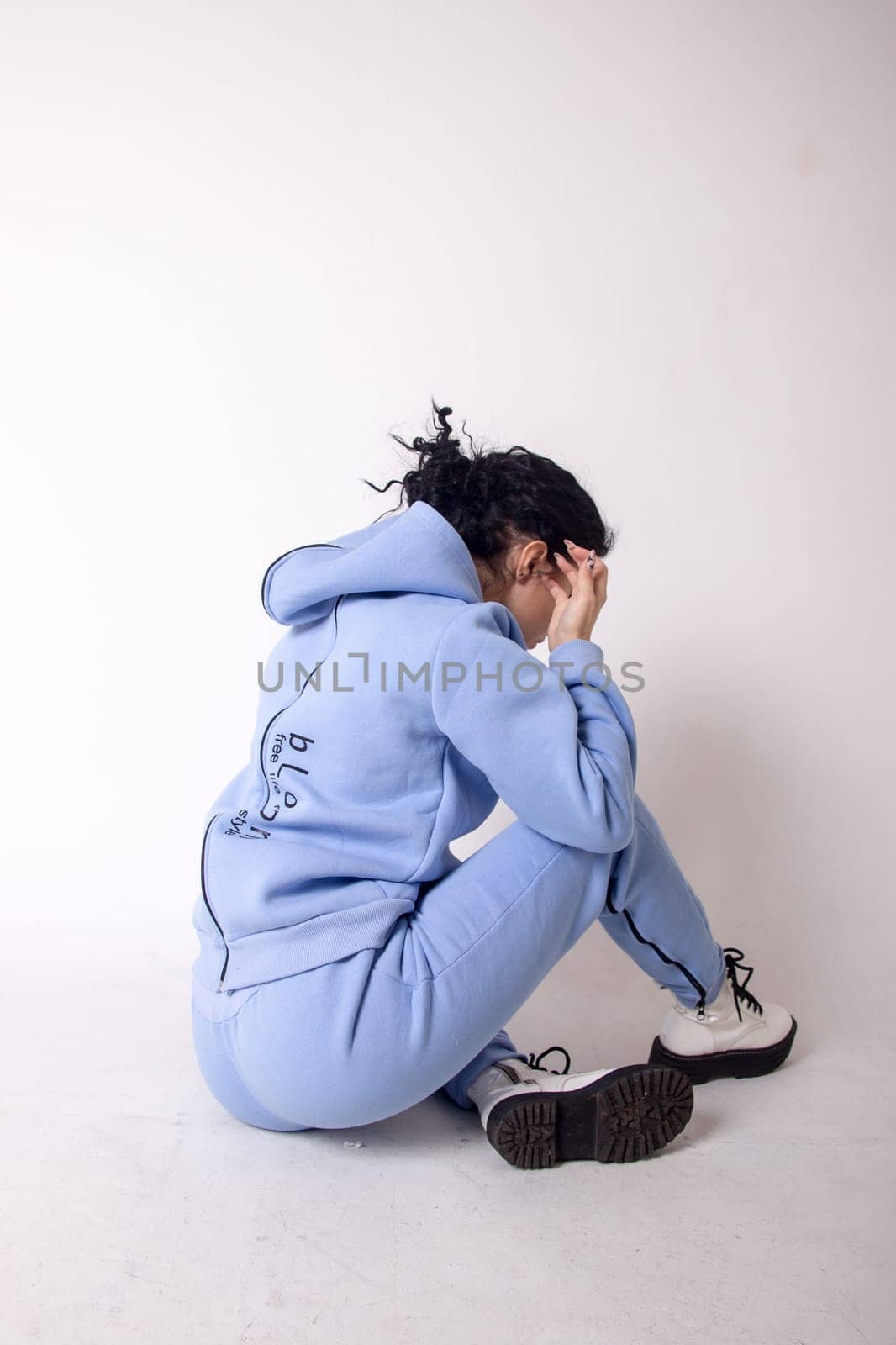 Fitness woman poses sitting, showing buttocks.