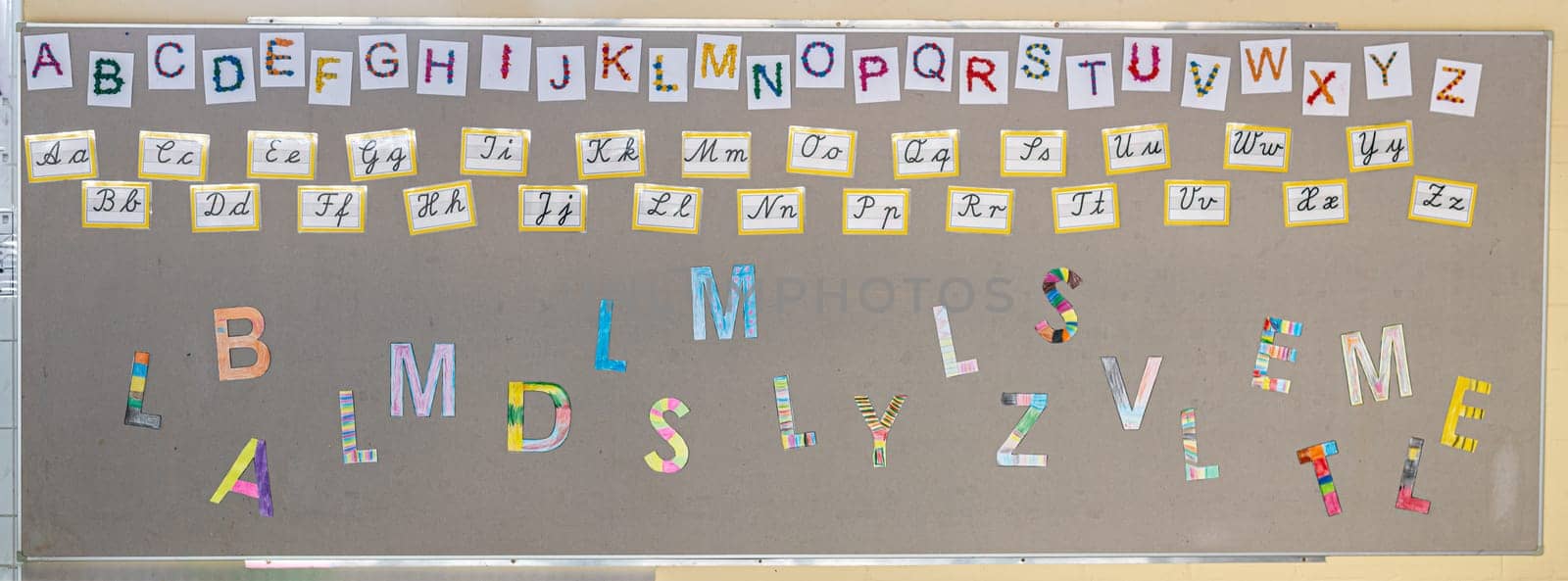 Colored letters, alphabet in block and cursive on the wall of a primary school