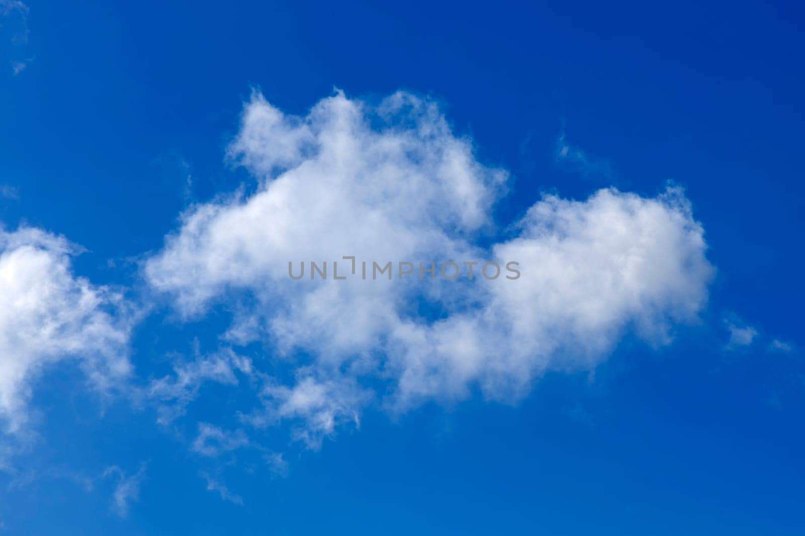 Background of a one single cumulus cloud with a blue clear sky