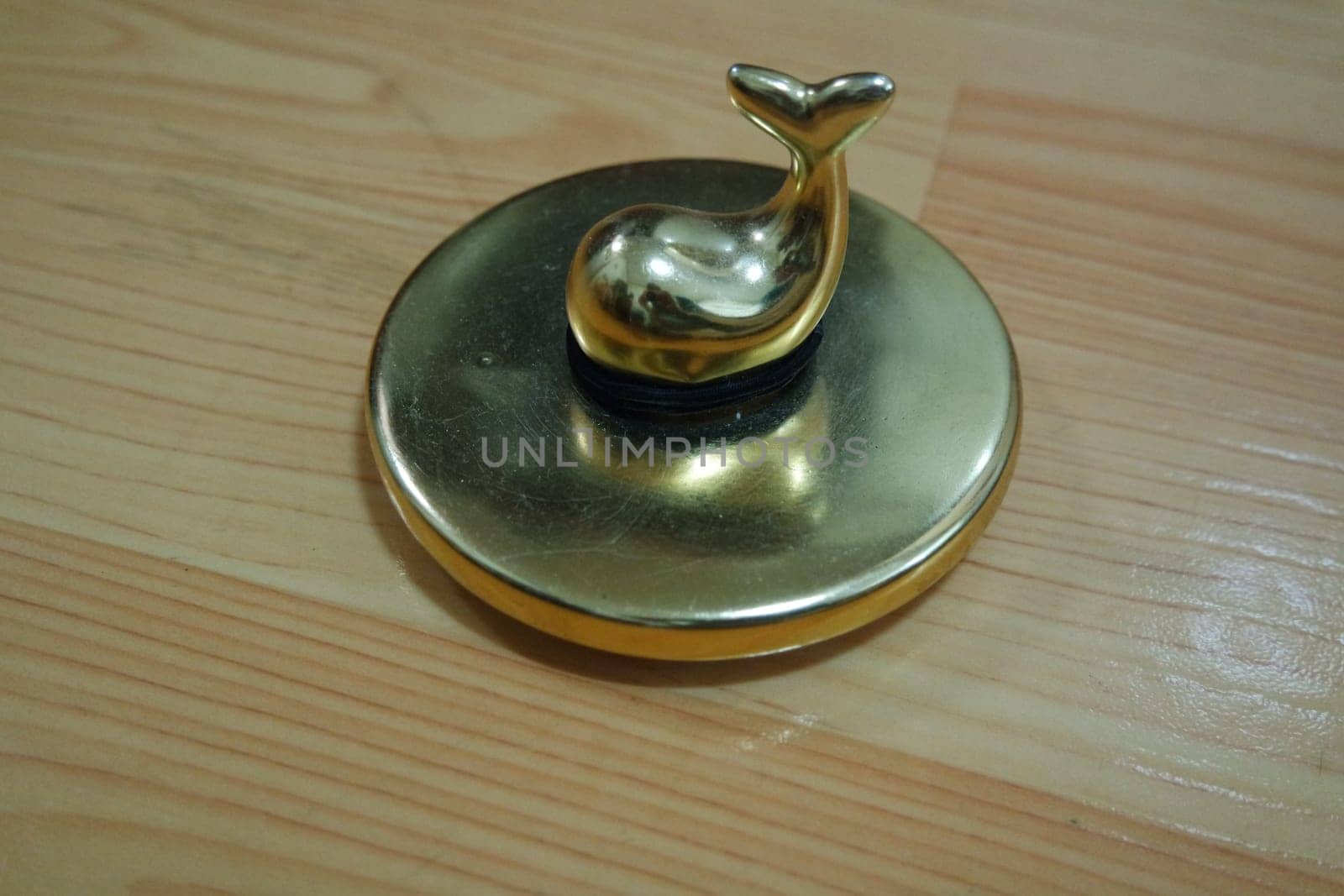 The decorative little golden pot with dolphin lid open, for room decoration. Golden pot on the vintage white background.